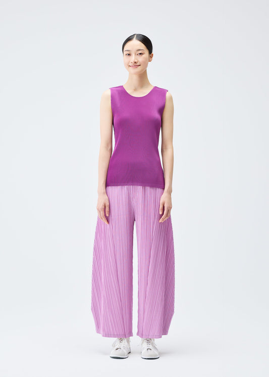 A model wears the Pleats Please Issey Miyake THICKER BOTTOMS 2 trousers.