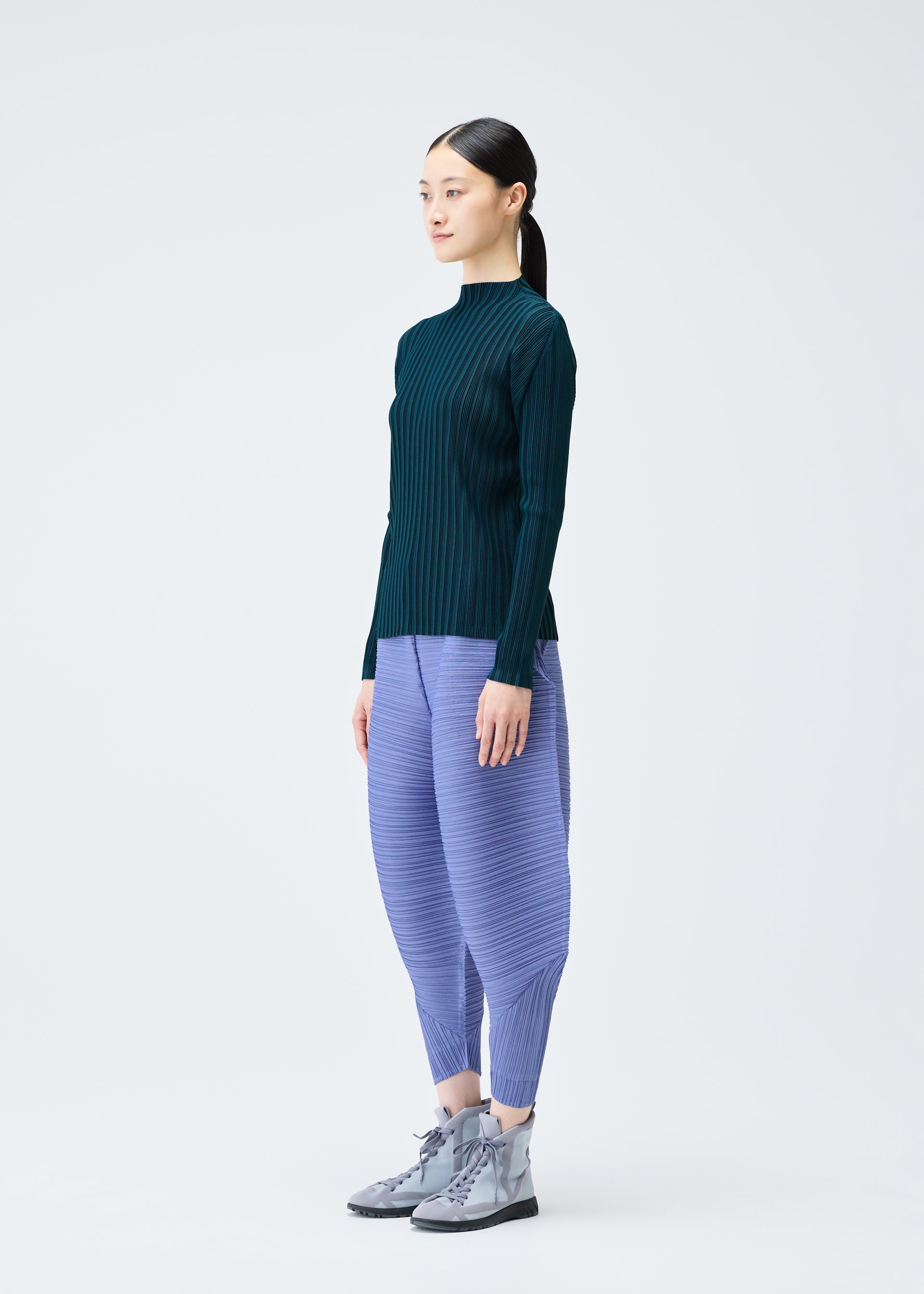 A model wears the Pleats Please Issey Miyake THICKER BOUNCE trousers.