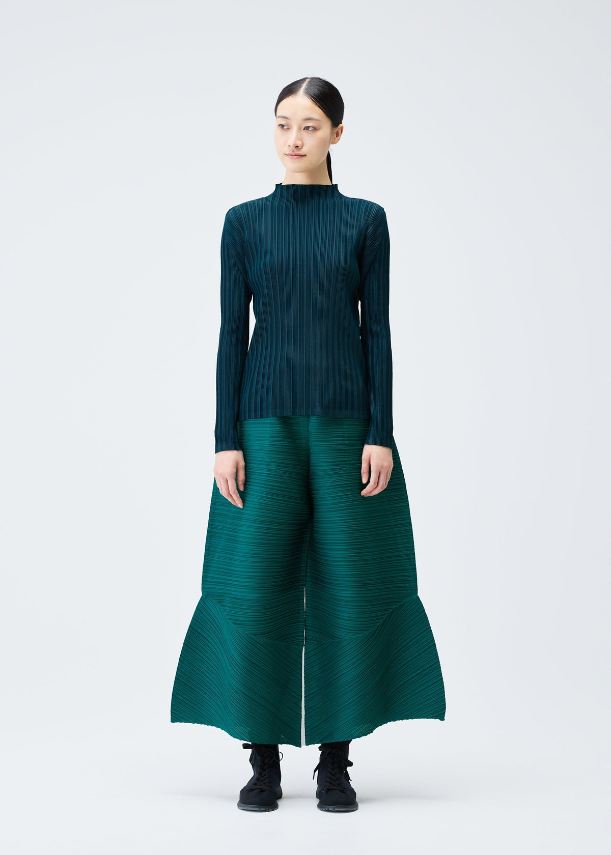 A model wears the Pleats Please Issey Miyake THICKER BOUNCE trousers.