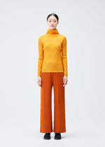 A model wears the Pleats Please Issey Miyake LOOP BOTTOMS trousers.