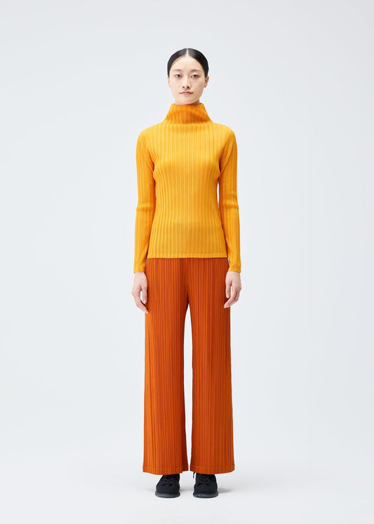 A model wears the Pleats Please Issey Miyake LOOP BOTTOMS trousers.