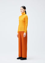 A model wears the Pleats Please Issey Miyake LOOP BOTTOMS trousers.