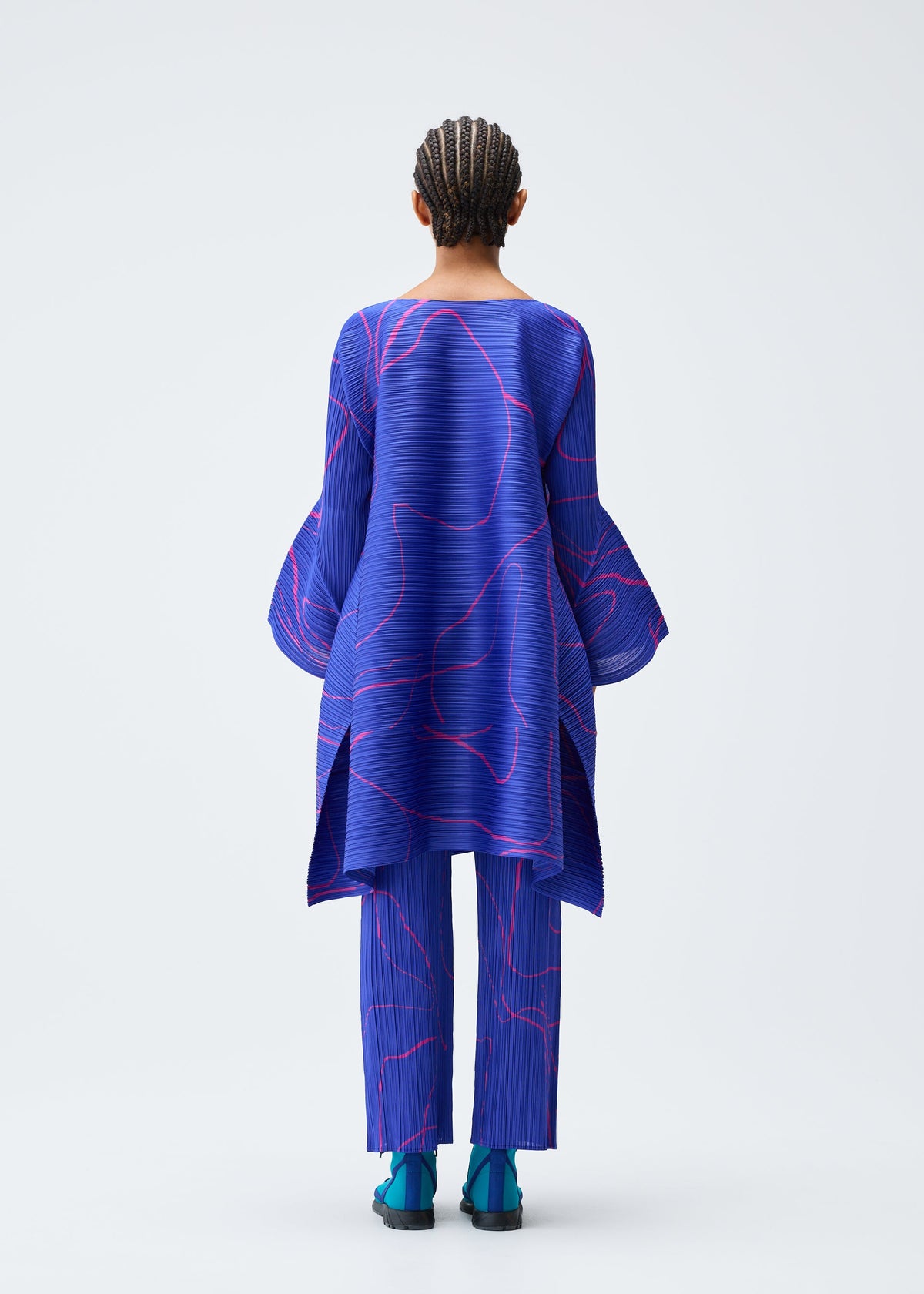 A model wears the Pleats Please Issey Miyake PAUSE trousers.