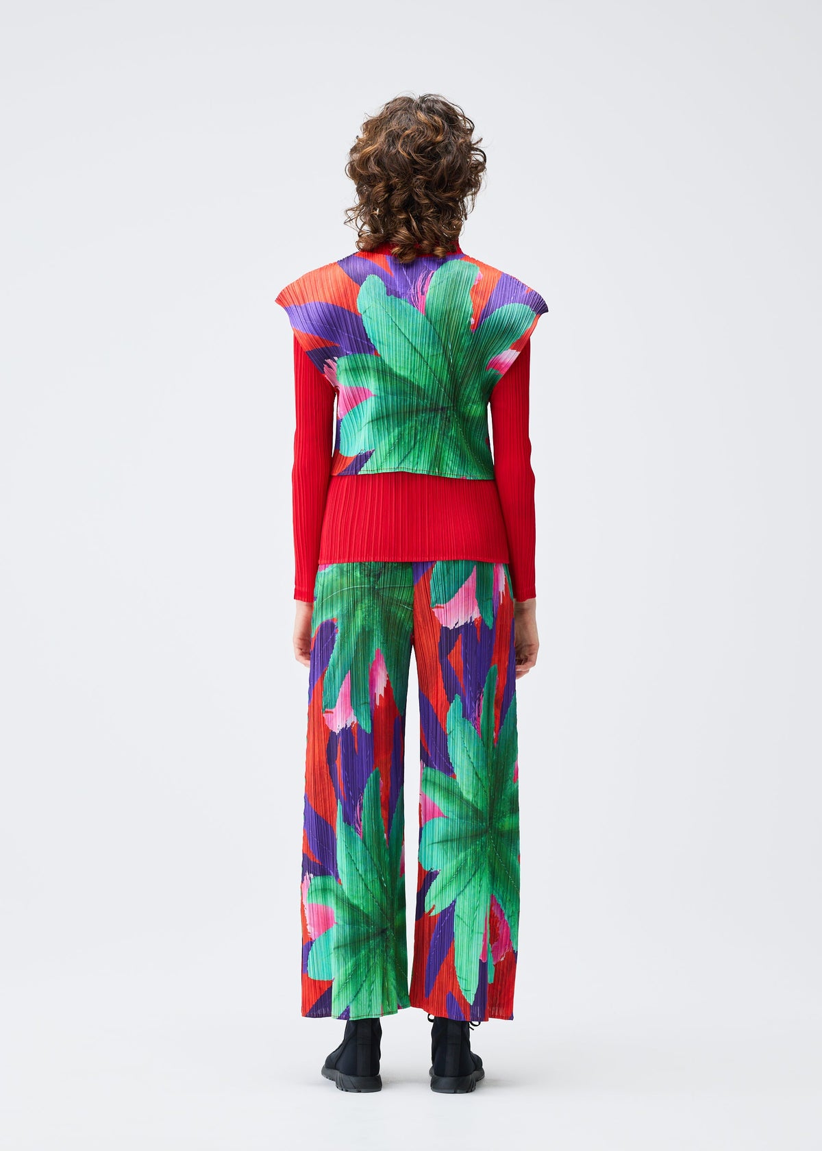 A model wears the Pleats Please Issey Miyake CARNIVAL trousers.