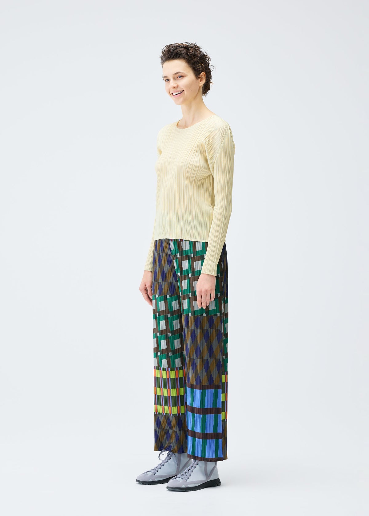 A model wears the Pleats Please Issey Miyake HARMONY trousers.