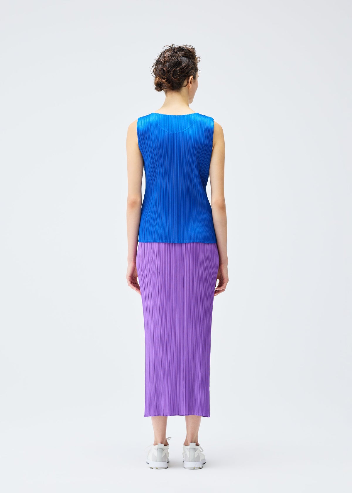 A model wears the PLEATS PLEASE ISSEY MIYAKE MONTHLY COLORS AUGUST skirt.