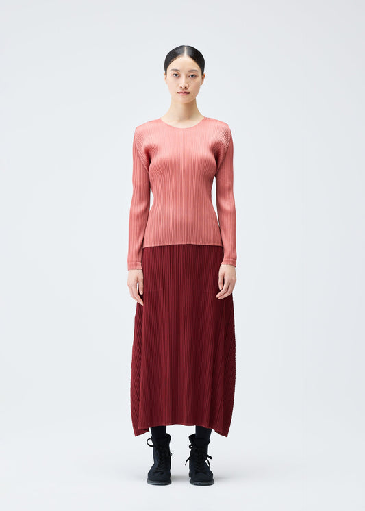 A model wears the PLEATS PLEASE ISSEY MIYAKE MONTHLY COLORS OCTOBER skirt.