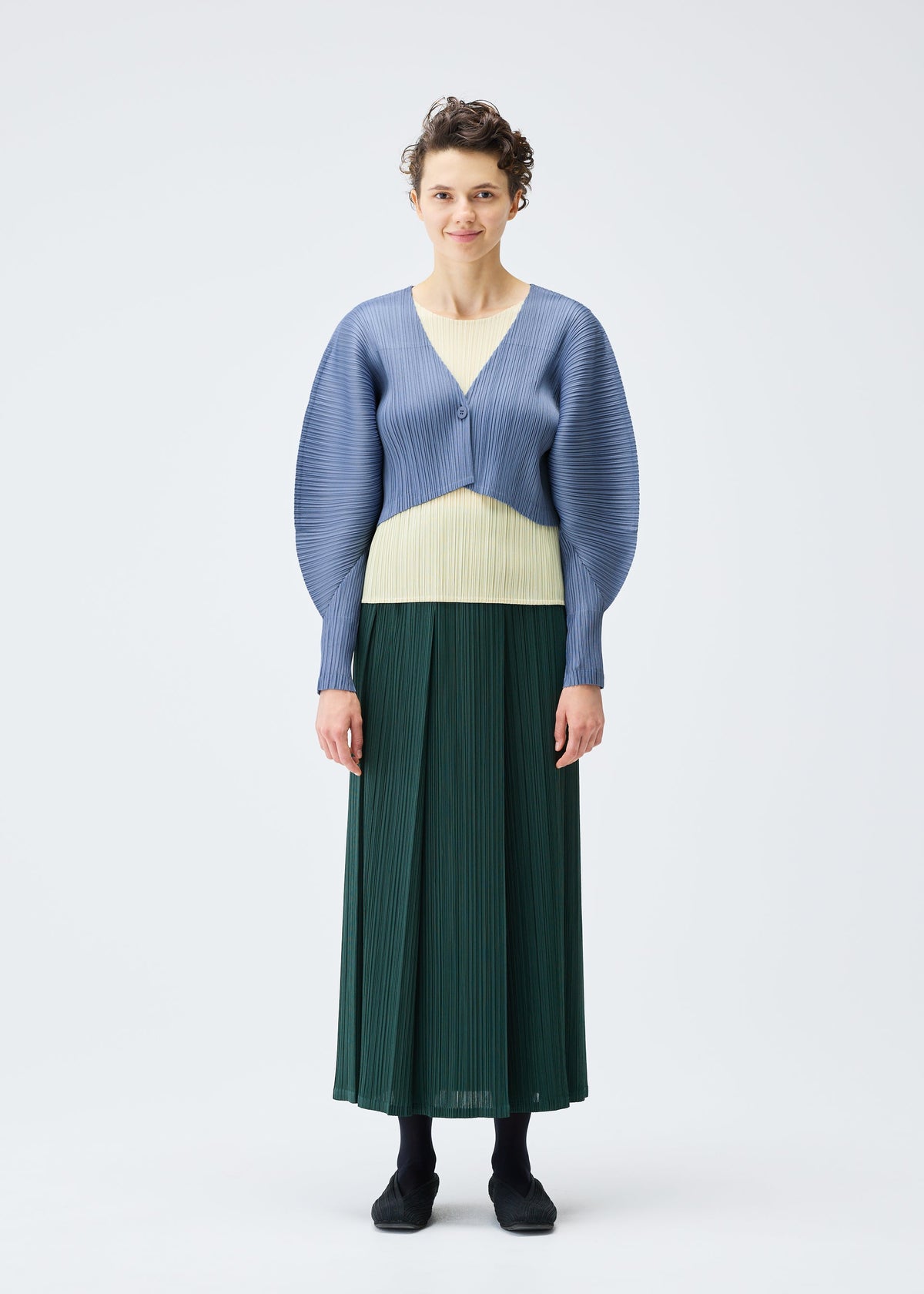 A model wears the Pleats Please Issey Miyake MONTHLY COLORS : DECEMBER skirt.