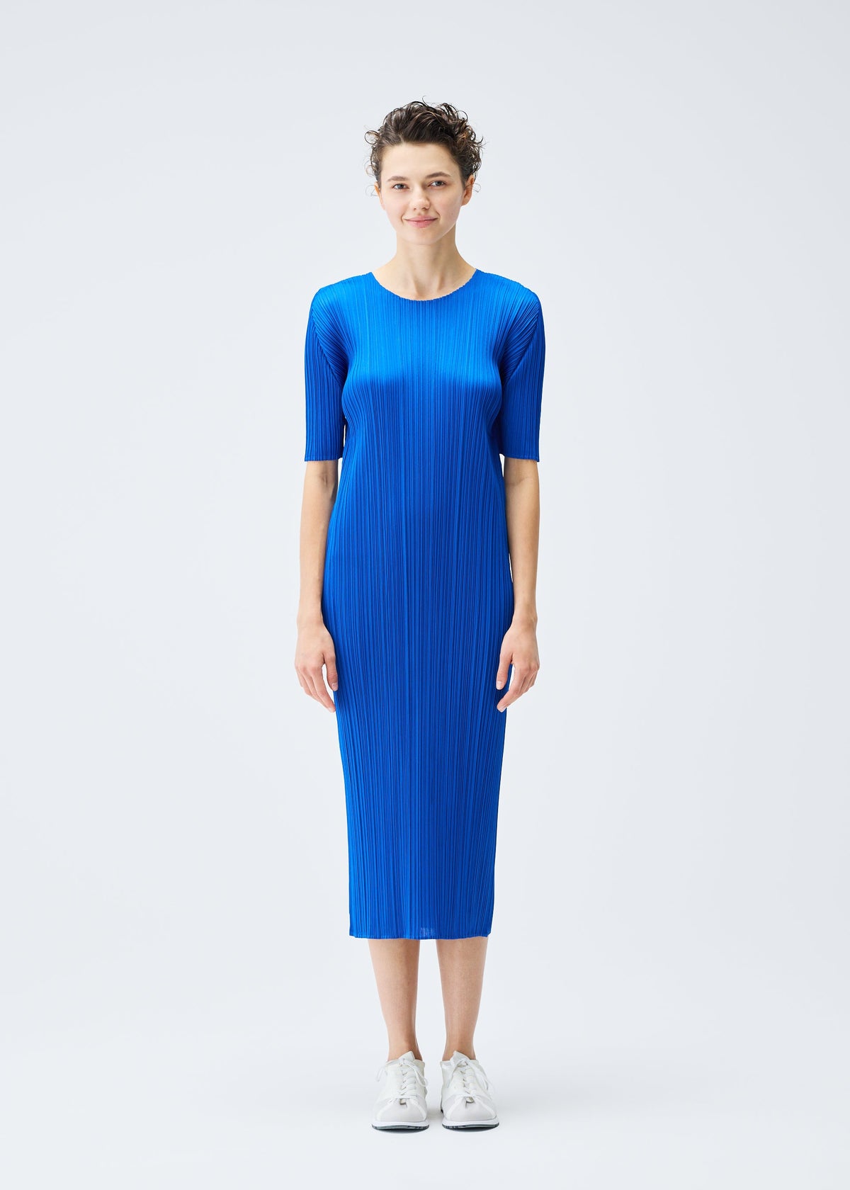 A model wears the PLEATS PLEASE ISSEY MIYAKE MONTHLY COLORS AUGUST dress.