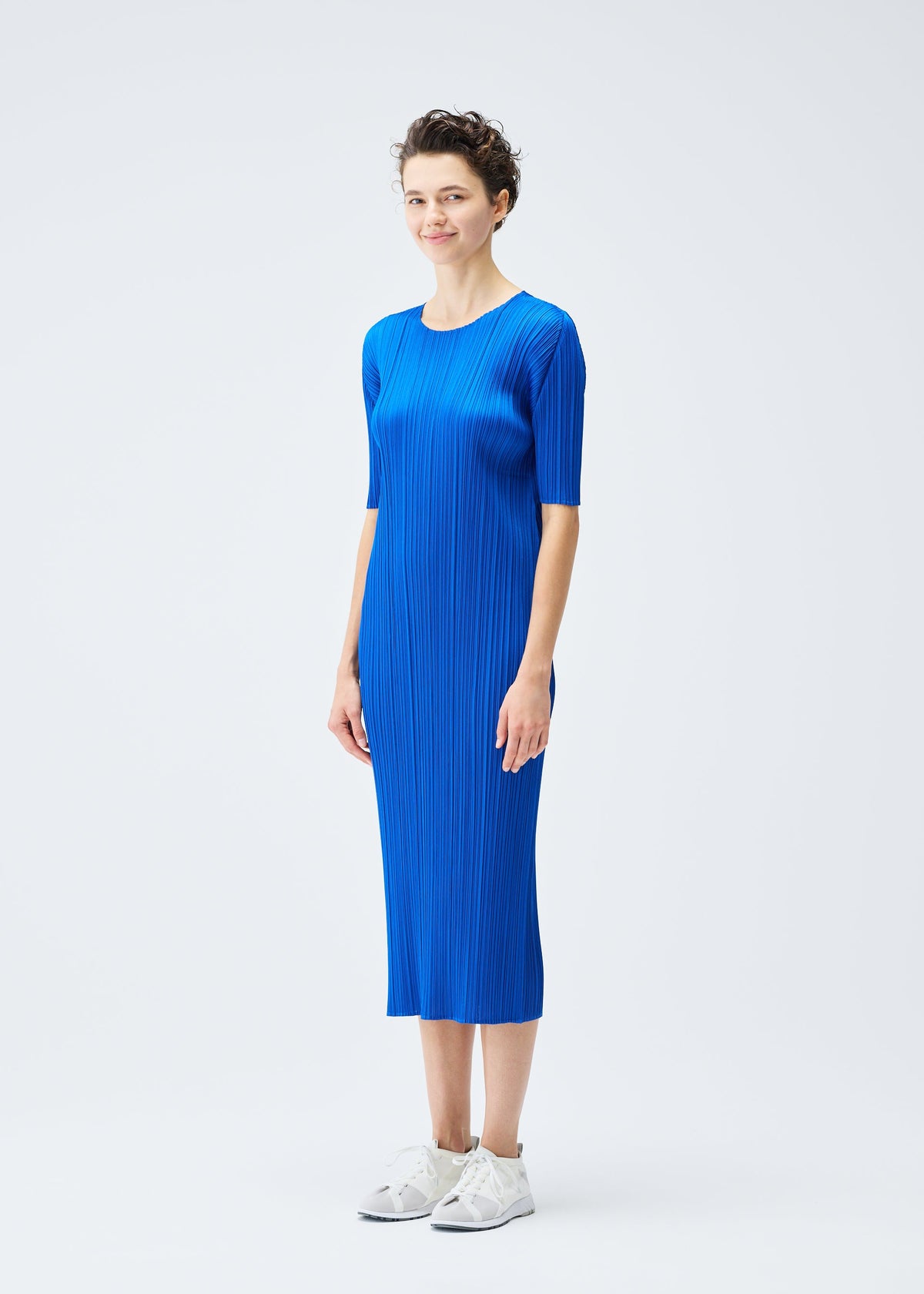 A model wears the PLEATS PLEASE ISSEY MIYAKE MONTHLY COLORS AUGUST dress.