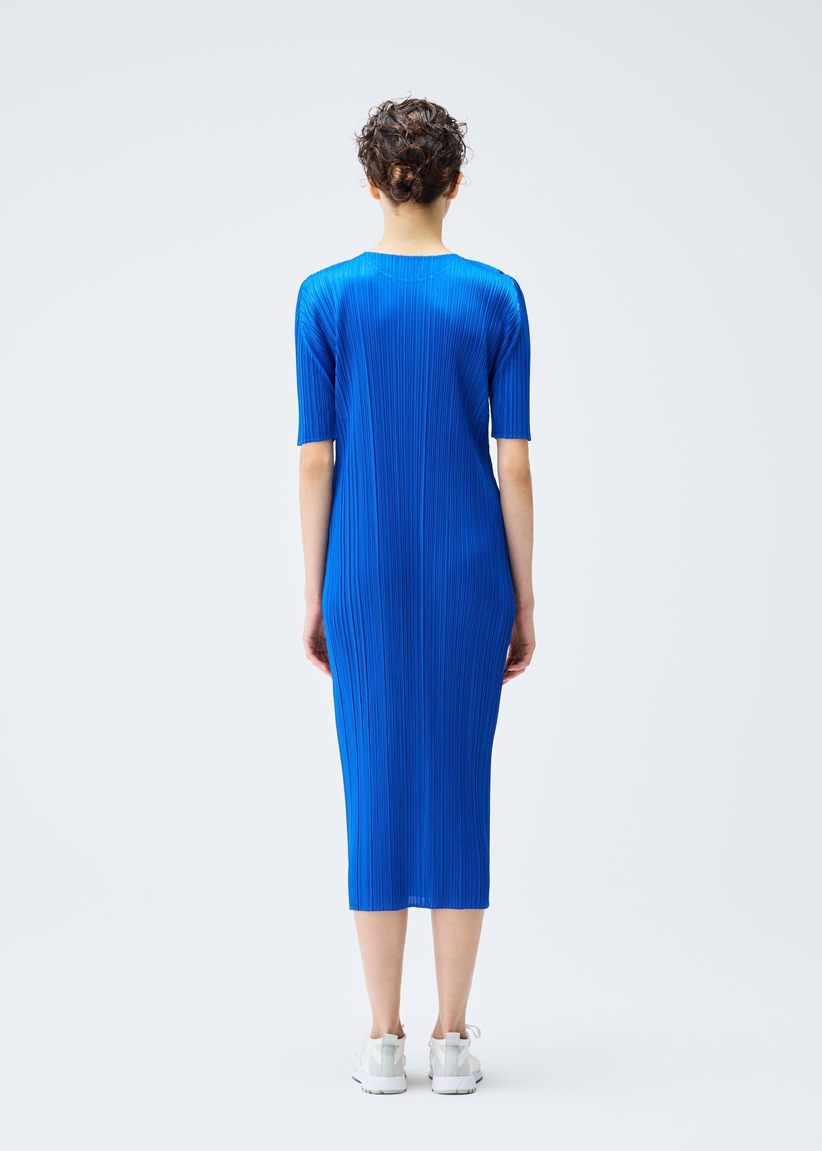 A model wears the PLEATS PLEASE ISSEY MIYAKE MONTHLY COLORS AUGUST dress.