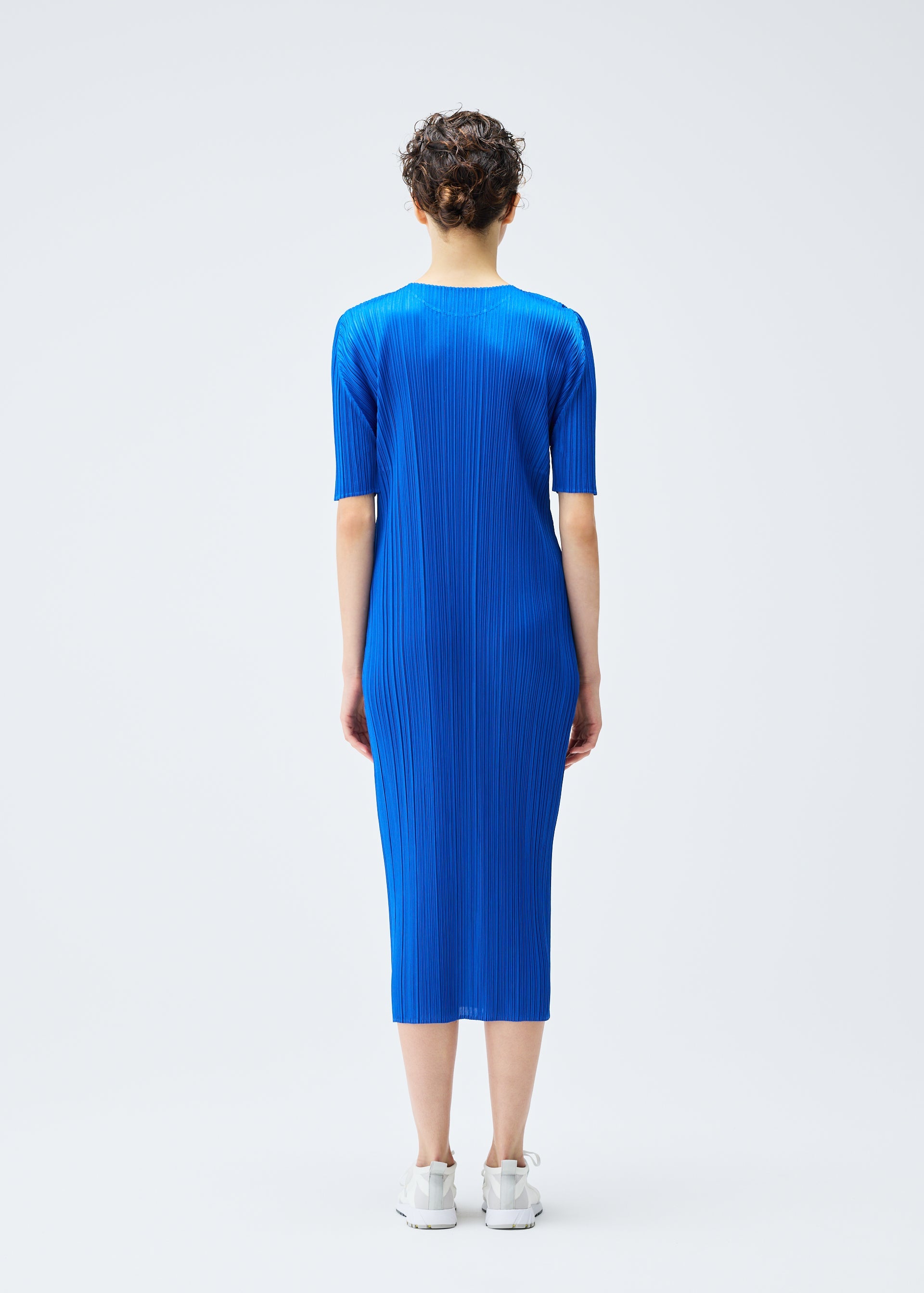 A model wears the PLEATS PLEASE ISSEY MIYAKE MONTHLY COLORS AUGUST dress.