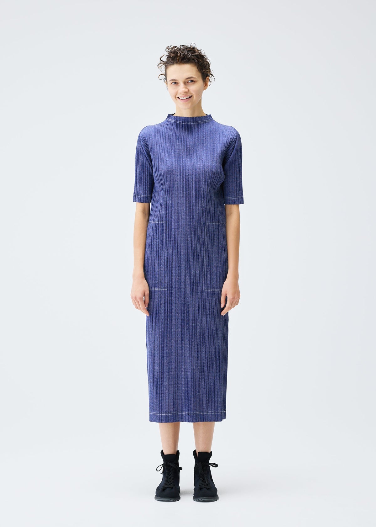A model wears the PLEATS PLEASE ISSEY MIYAKE COTTON DENIM dress.
