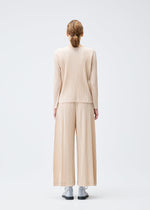 A model wears the Pleats Please Issey Miyake WOOL PLEATS shirt.