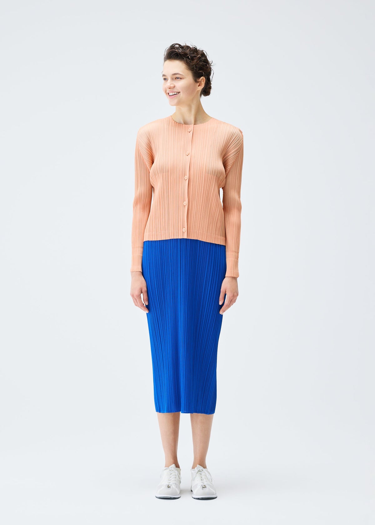 A model wears the PLEATS PLEASE ISSEY MIYAKE MONTHLY COLORS AUGUST cardigan.