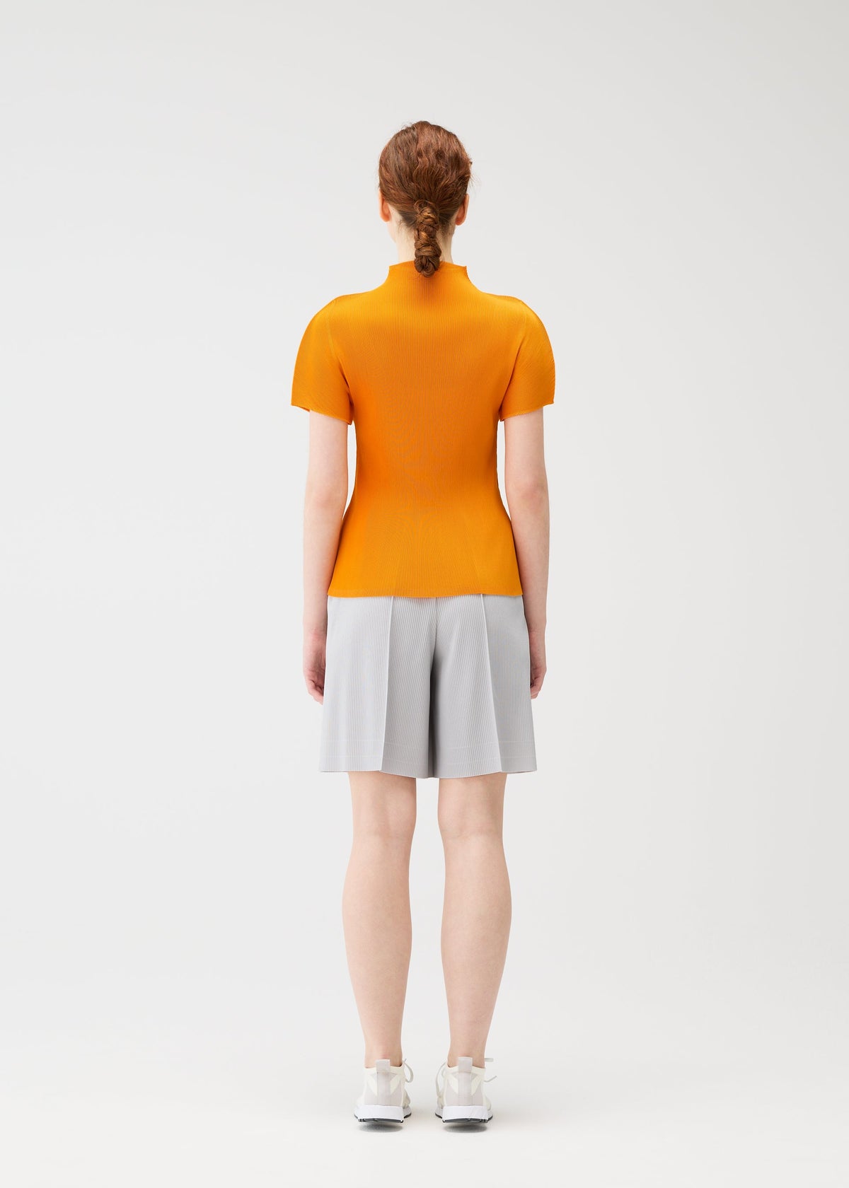 A model wears the Pleats Please Issey Miyake MIST APRIL shirt.