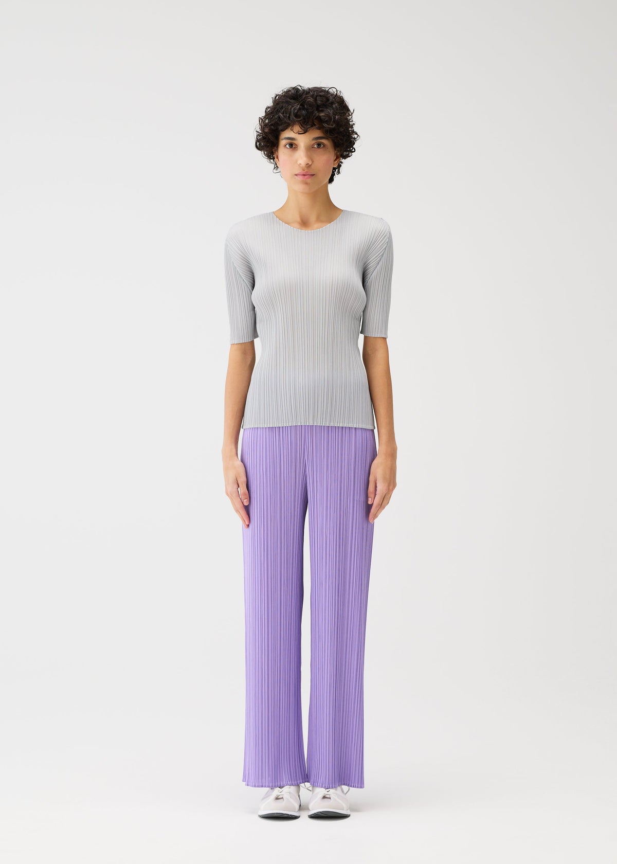 A model wears the Pleats Please Issey Miyake MONTHLY COLORS pants.
