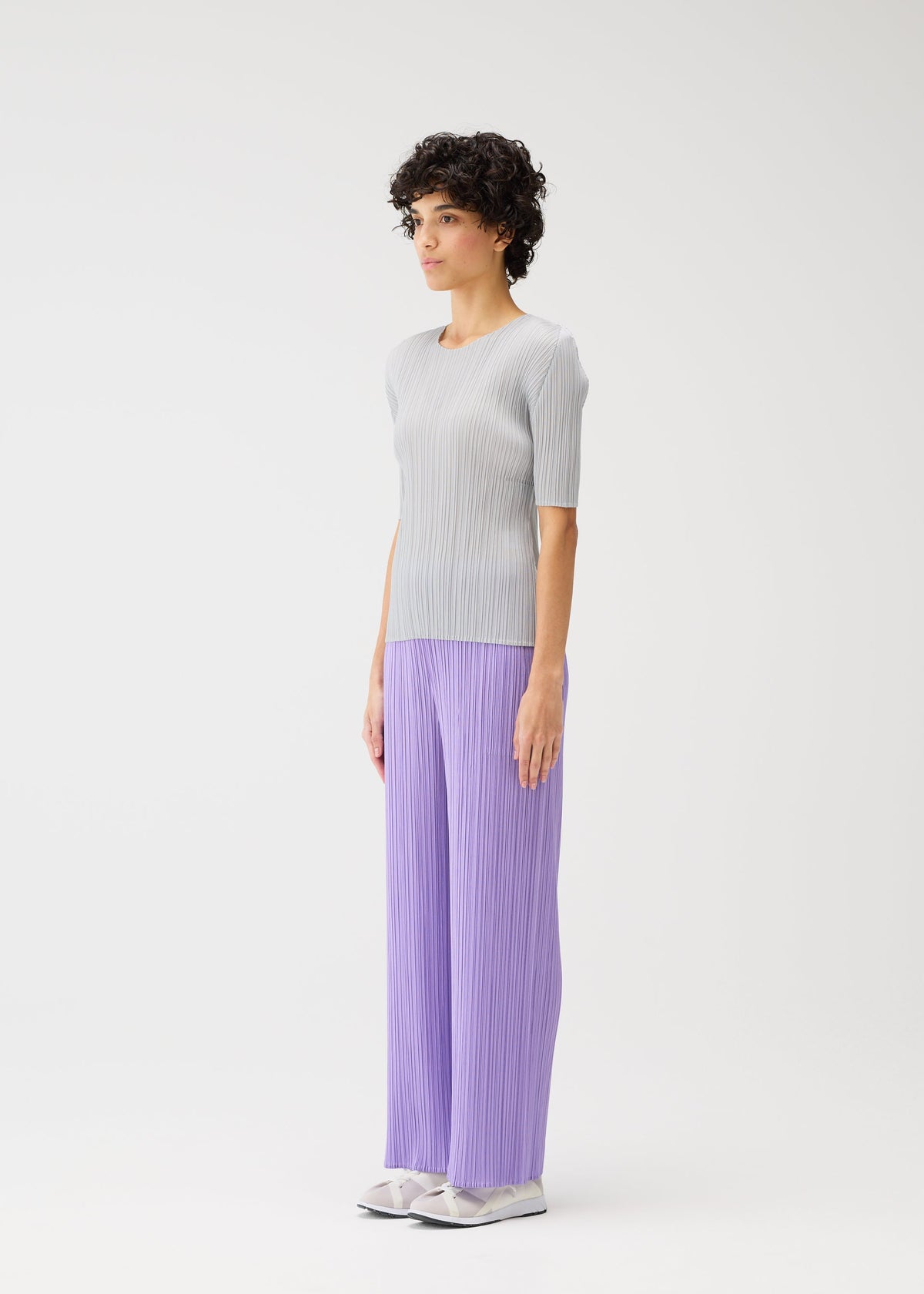 A model wears the Pleats Please Issey Miyake MONTHLY COLORS pants.