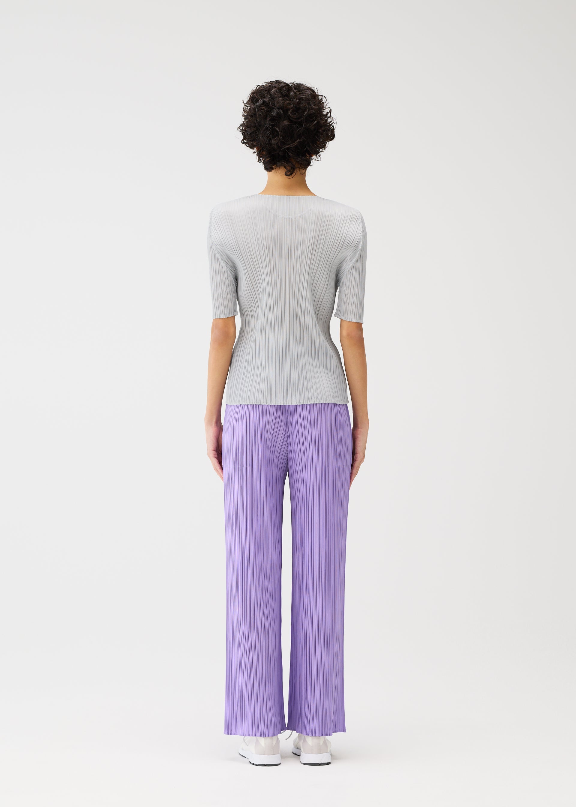 A model wears the Pleats Please Issey Miyake MONTHLY COLORS pants.