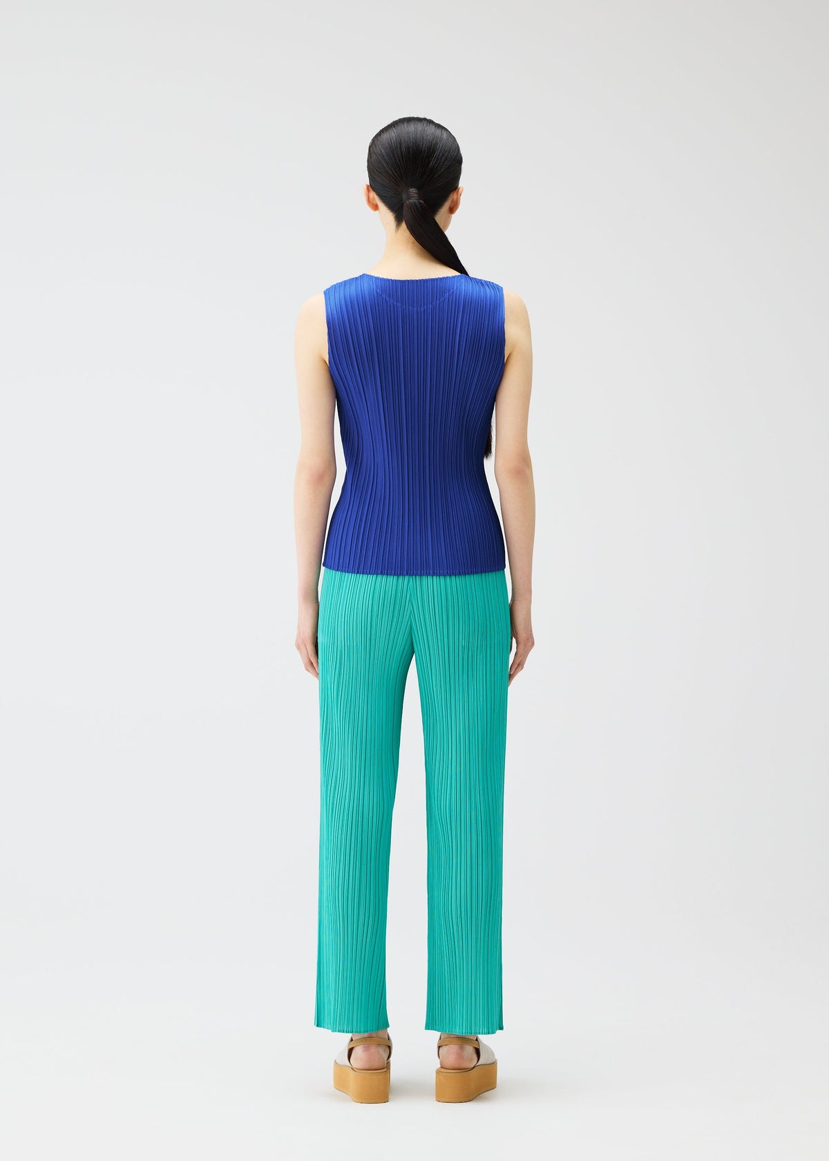 A model wears the Pleats Please Issey Miyake MONTHLY COLORS MAY trousers.