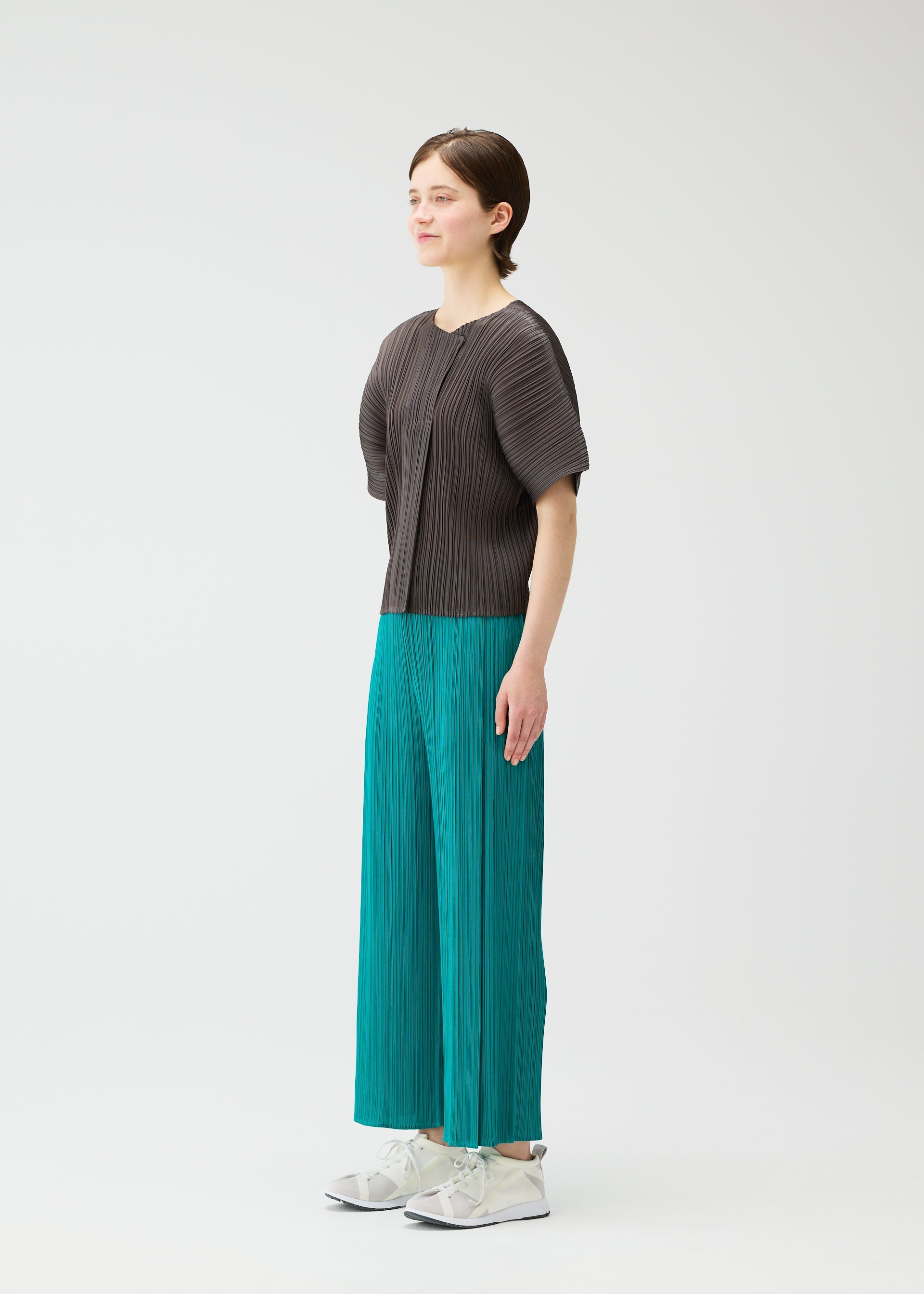 A model wears the PLEATS PLEASE ISSEY MIYAKE MONTHLY COLORS : JUNE monthly-colors-june-trousers-bright-pink-3.