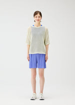 A model wears the Pleats Please Issey Miyake LOOP BOTTOMS trousers.