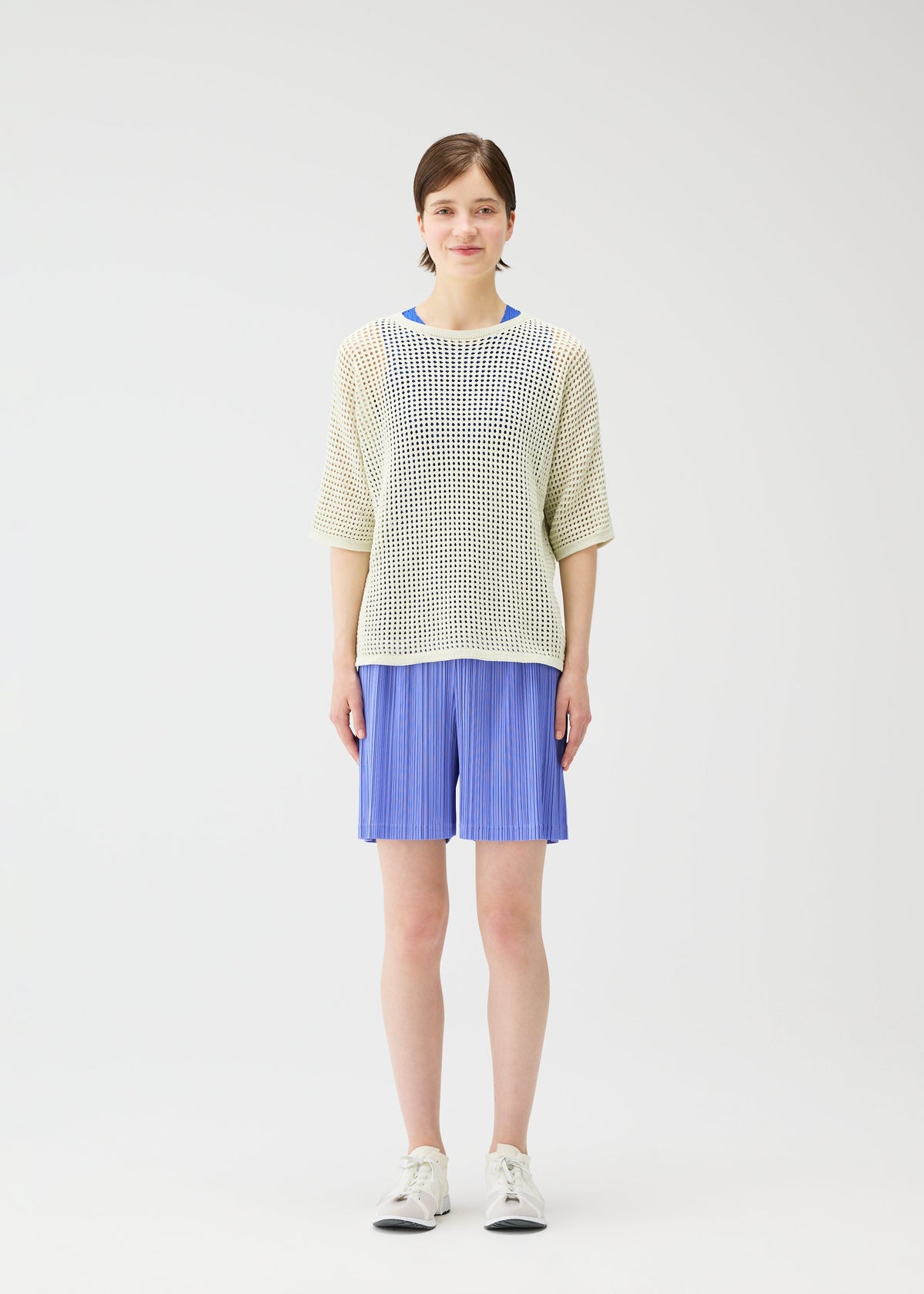 A model wears the Pleats Please Issey Miyake LOOP BOTTOMS trousers.