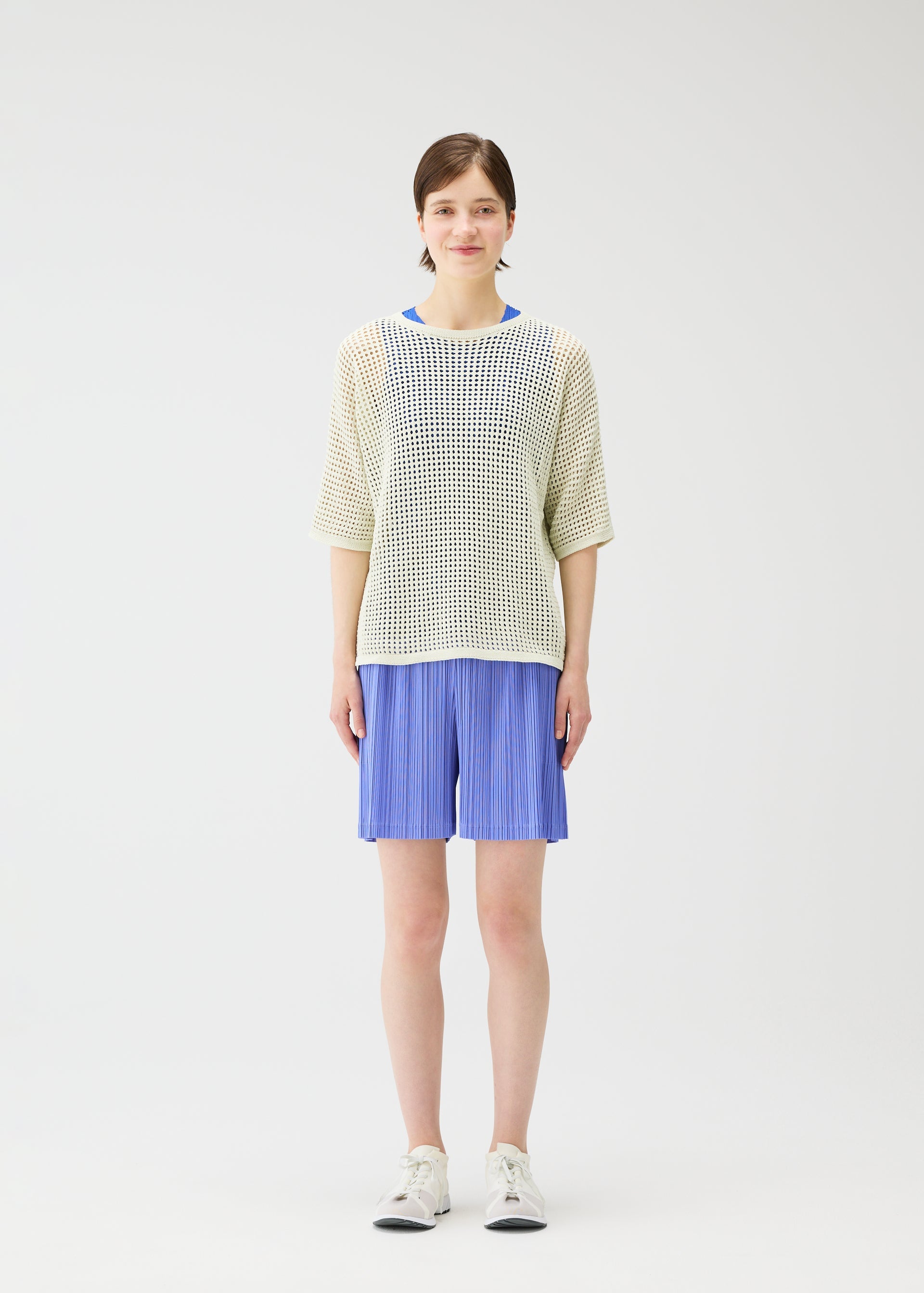 A model wears the Pleats Please Issey Miyake LOOP BOTTOMS trousers.