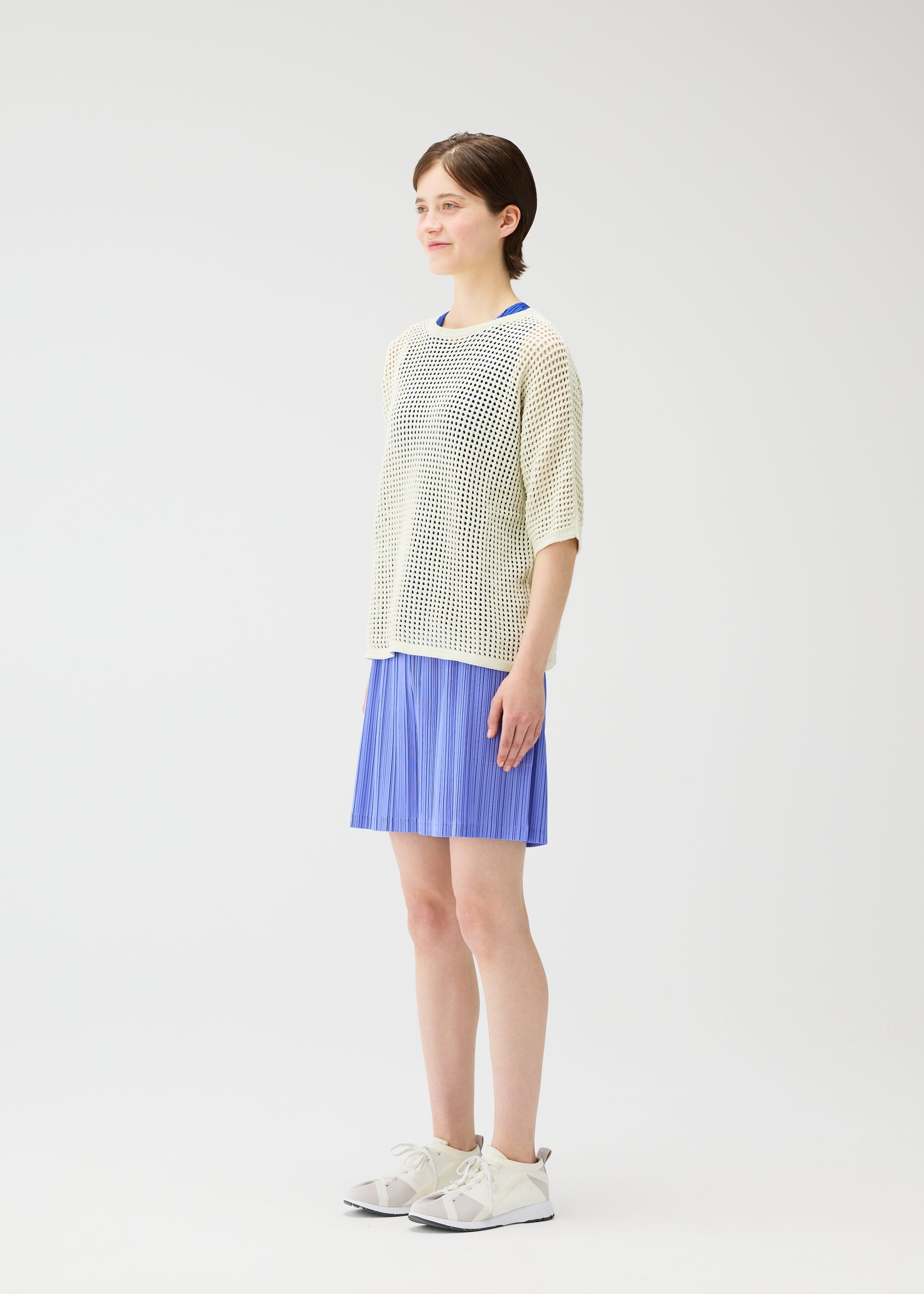 A model wears the Pleats Please Issey Miyake LOOP BOTTOMS trousers.