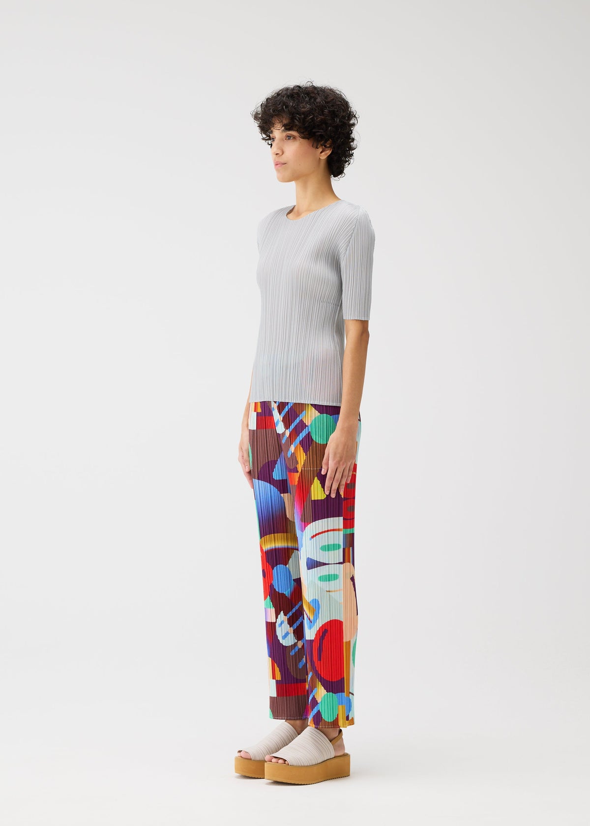 A model wears the Pleats Please Issey Miyake SODA POPS pants.