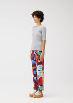 A model wears the Pleats Please Issey Miyake SODA POPS pants.