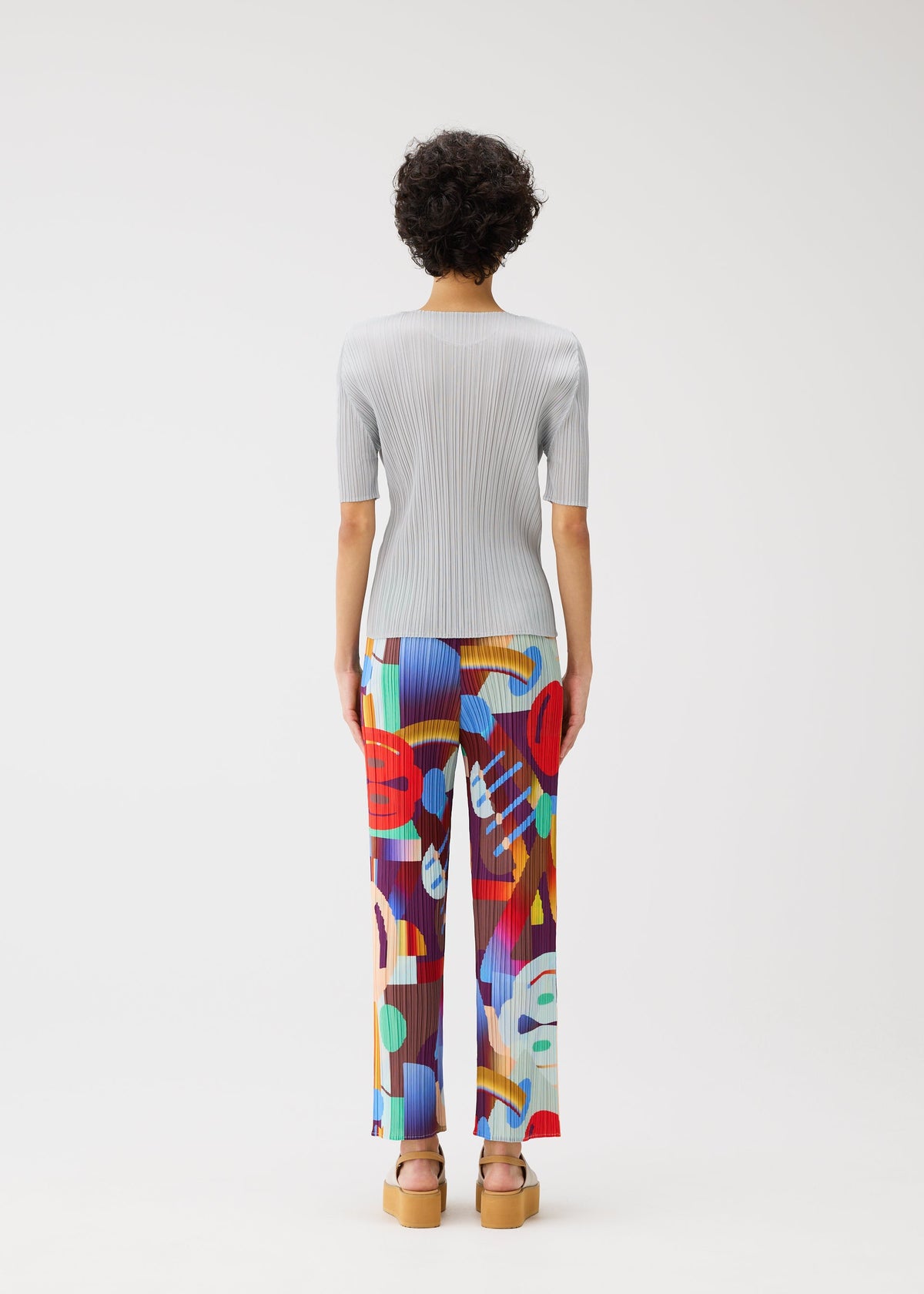 A model wears the Pleats Please Issey Miyake SODA POPS pants.
