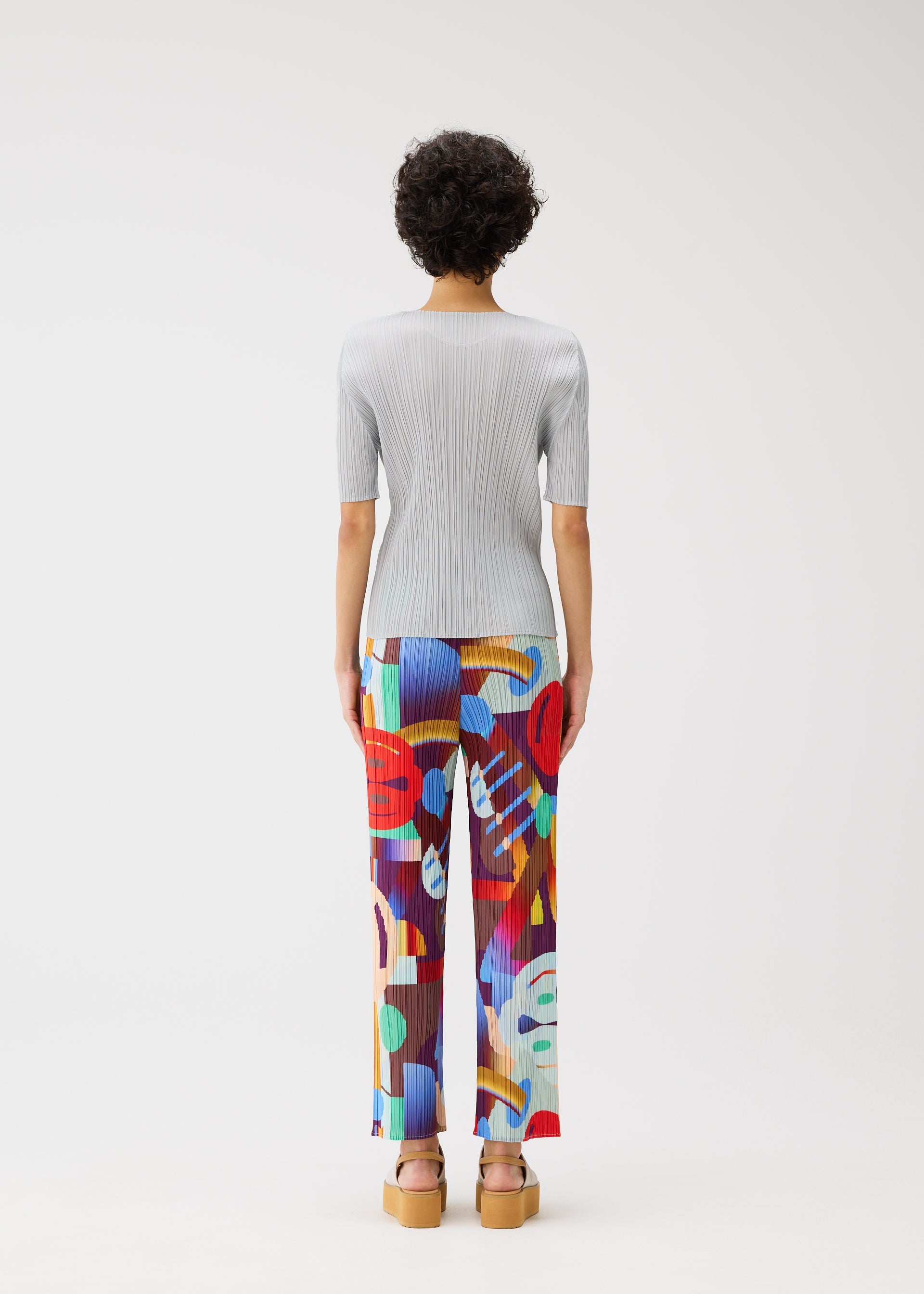 A model wears the Pleats Please Issey Miyake SODA POPS pants.