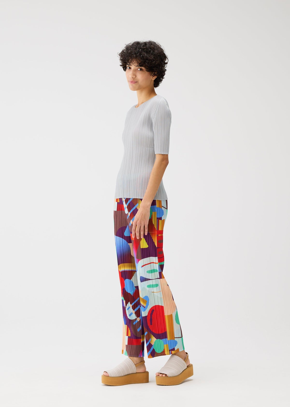 A model wears the Pleats Please Issey Miyake SODA POPS pants.