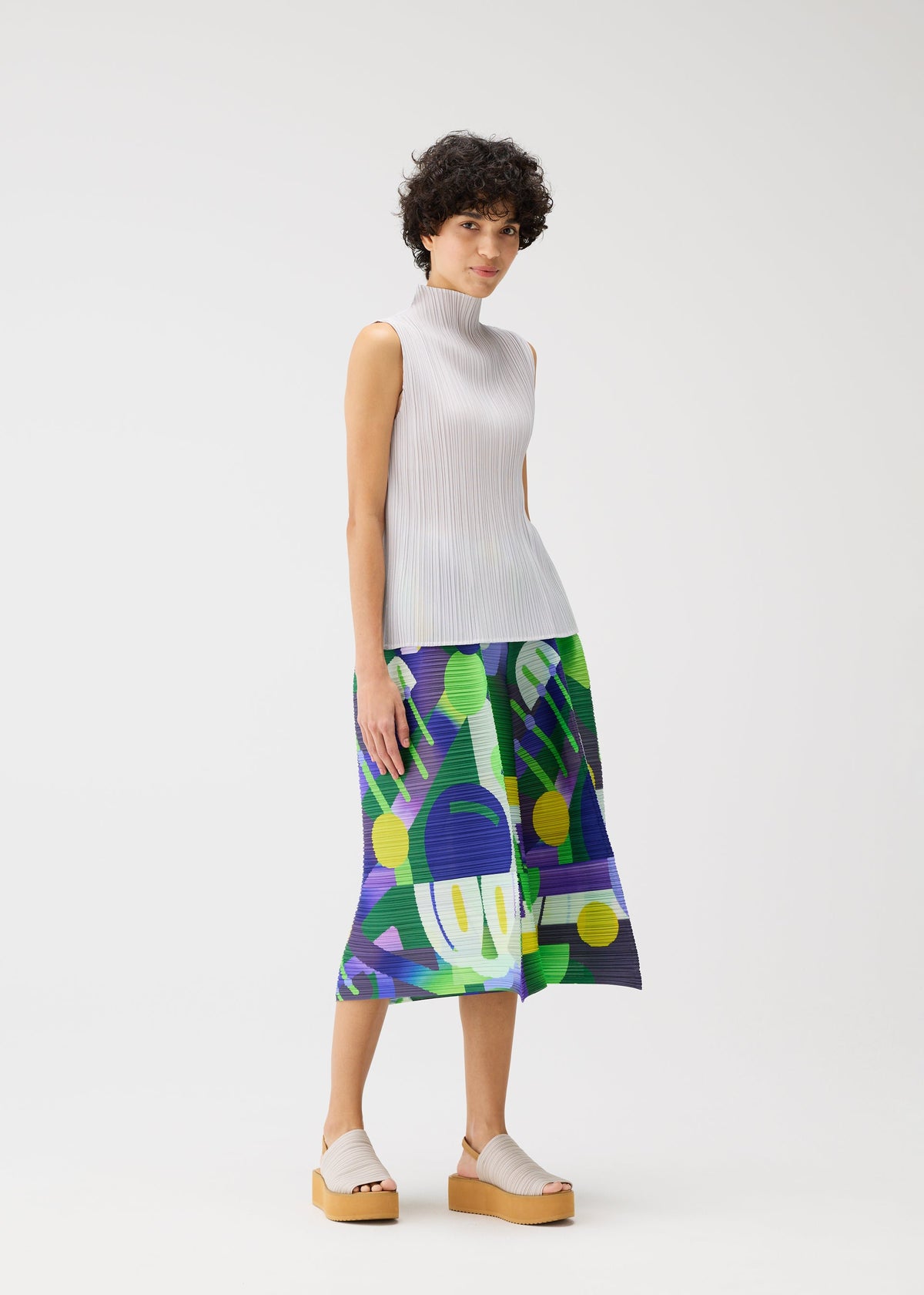 A model wears the Pleats Please Issey Miyake SODA POPS pants.