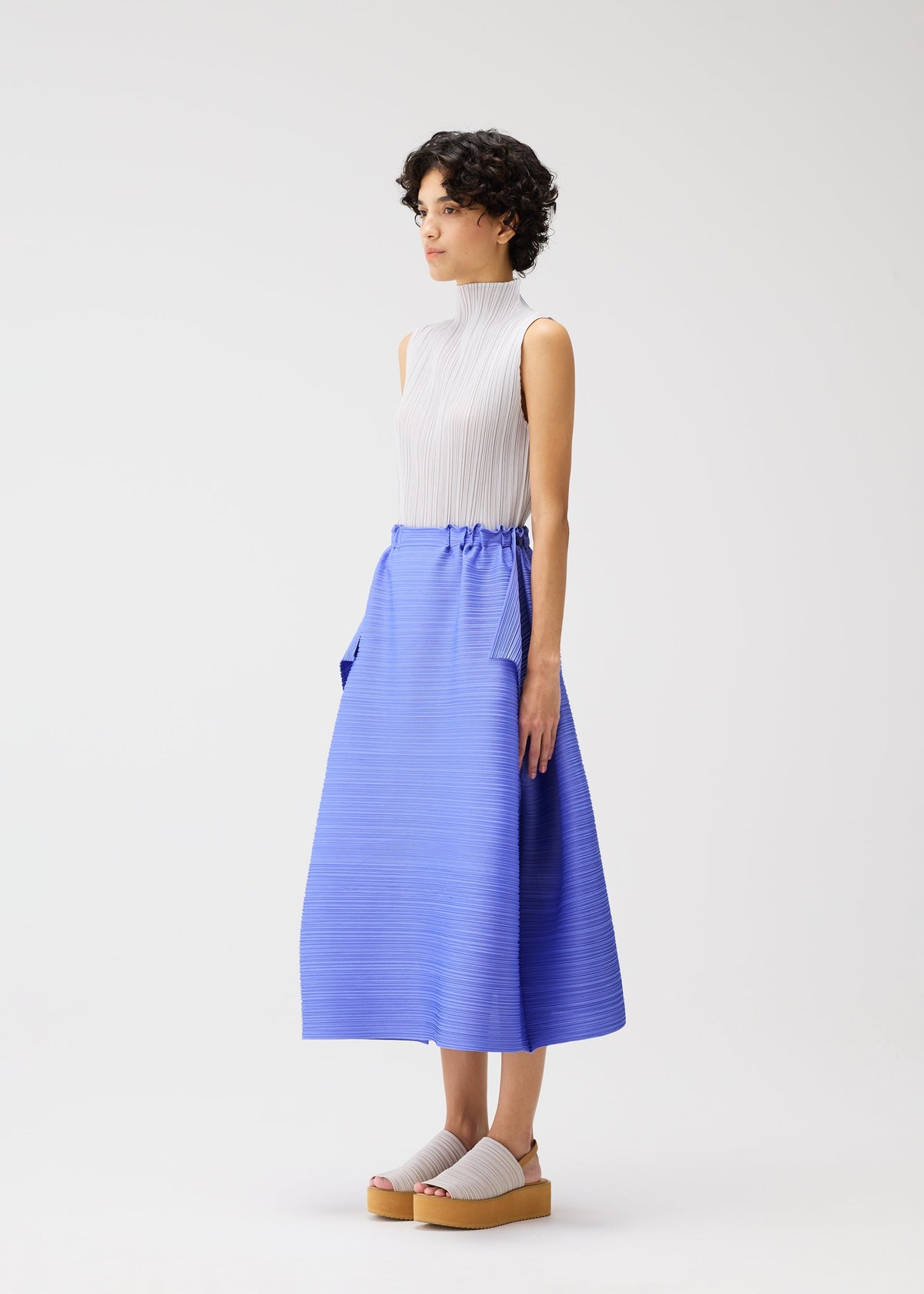 A model wears the PLEATS PLEASE ISSEY MIYAKE BOUNCY BASKET bouncy-basket-skirt-yellow-green.