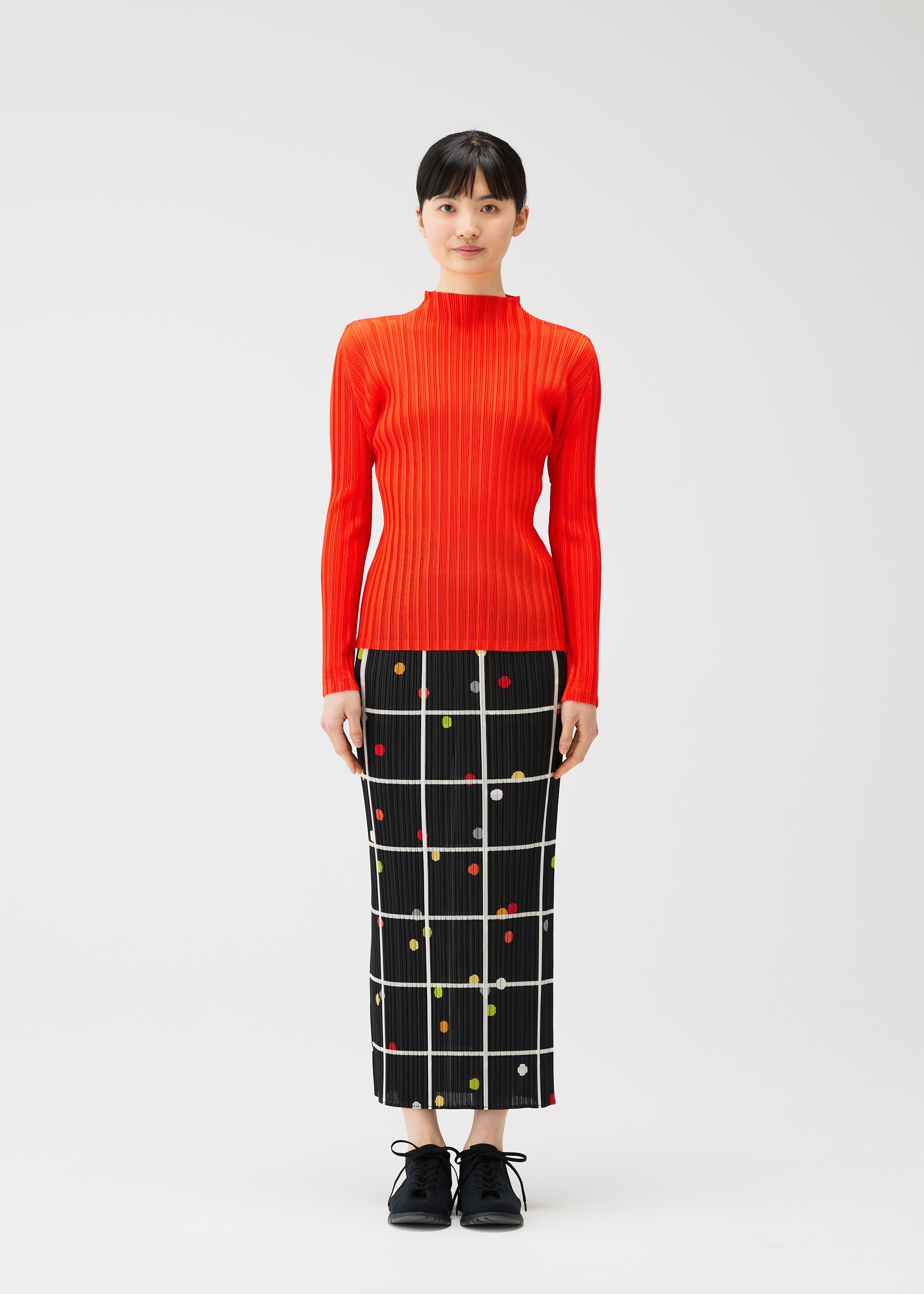A model wears the PLEATS PLEASE ISSEY MIYAKE CROSSING DOTS prêt à porter.