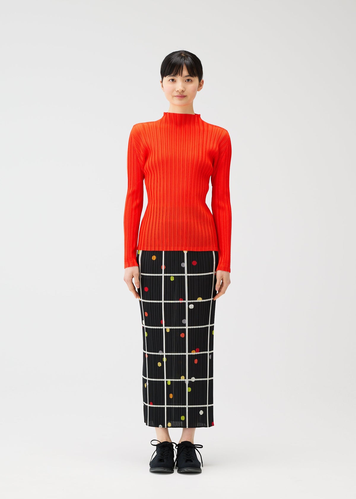 A model wears the PLEATS PLEASE ISSEY MIYAKE CROSSING DOTS prêt à porter.