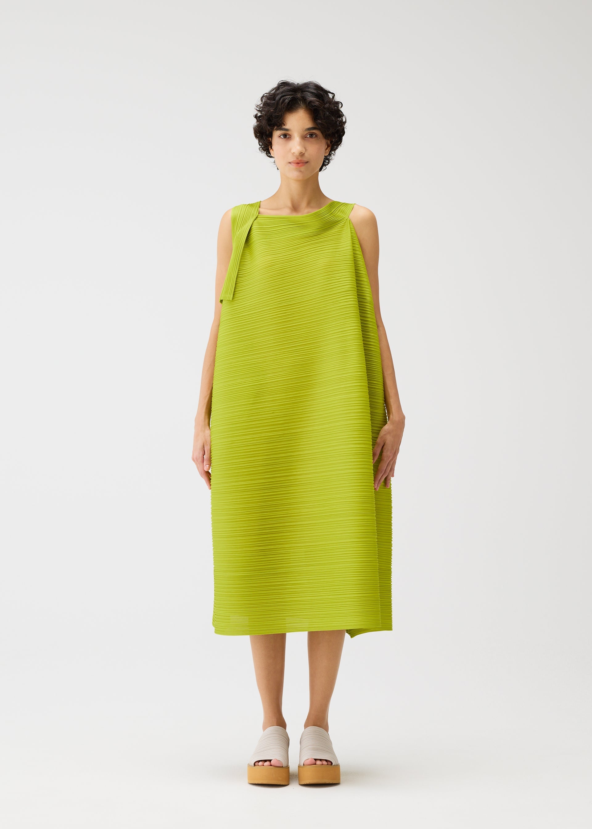 A model wears the PLEATS PLEASE ISSEY MIYAKE BOUNCY BASKET bouncy-basket-dress-yellow-green.