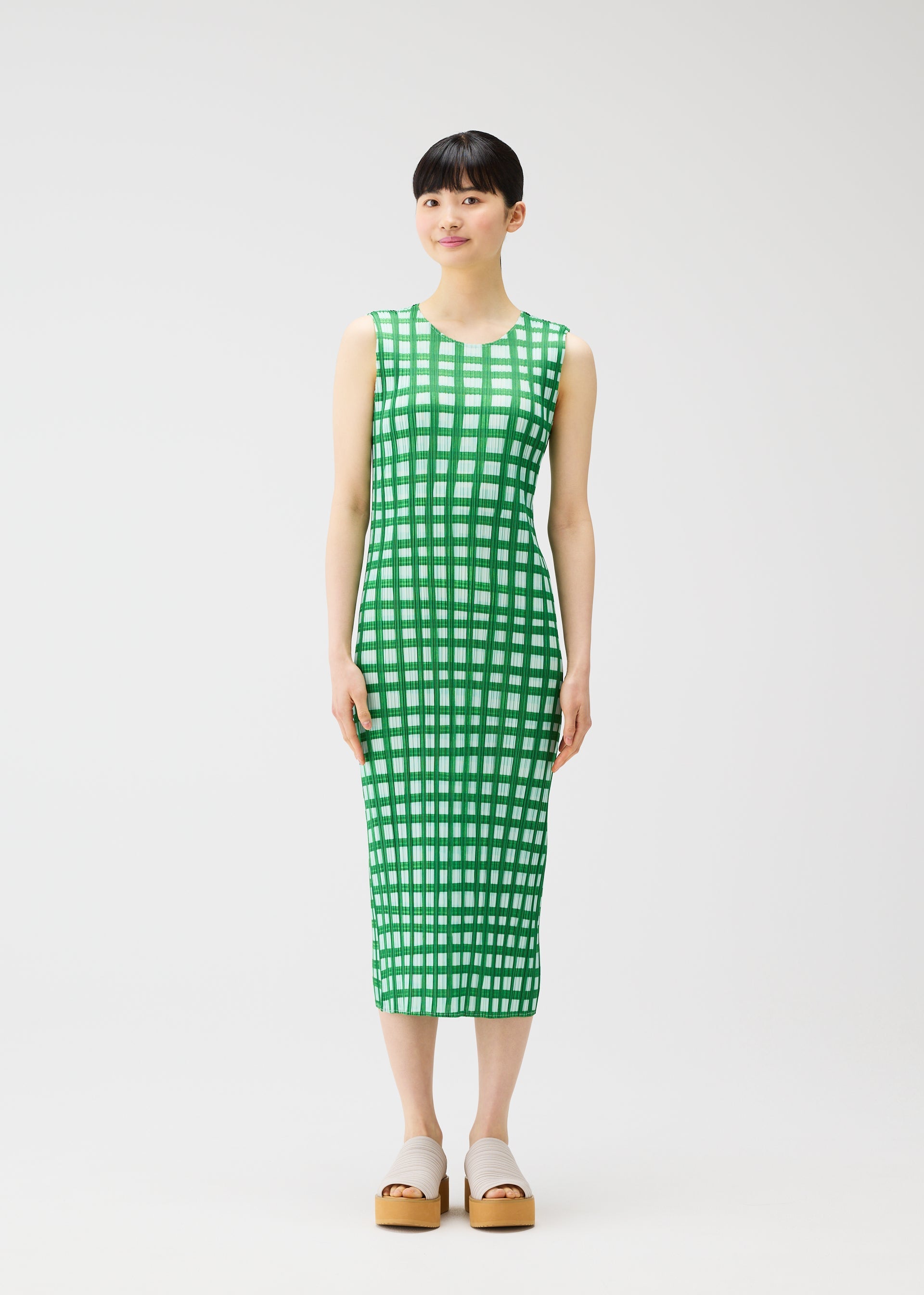 A model wears the PLEATS PLEASE ISSEY MIYAKE BASKET basket-dress-green.