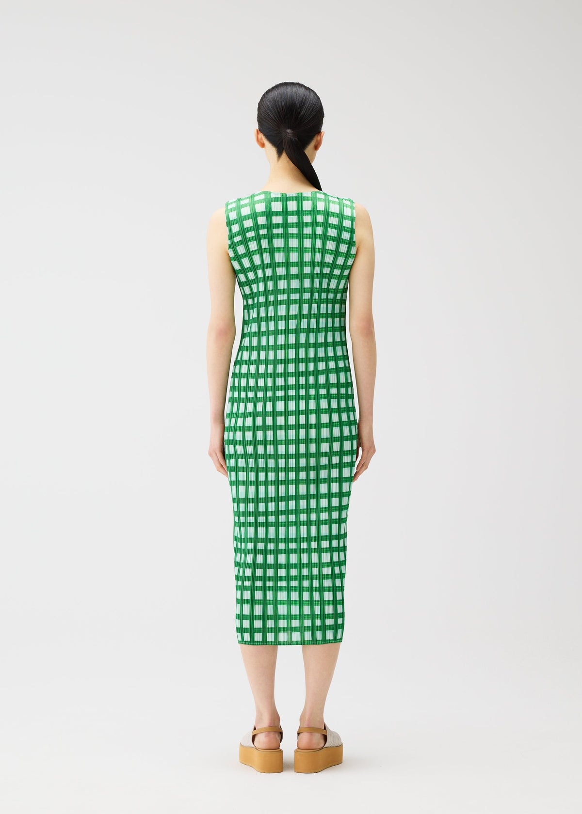 A model wears the PLEATS PLEASE ISSEY MIYAKE BASKET basket-dress-green.