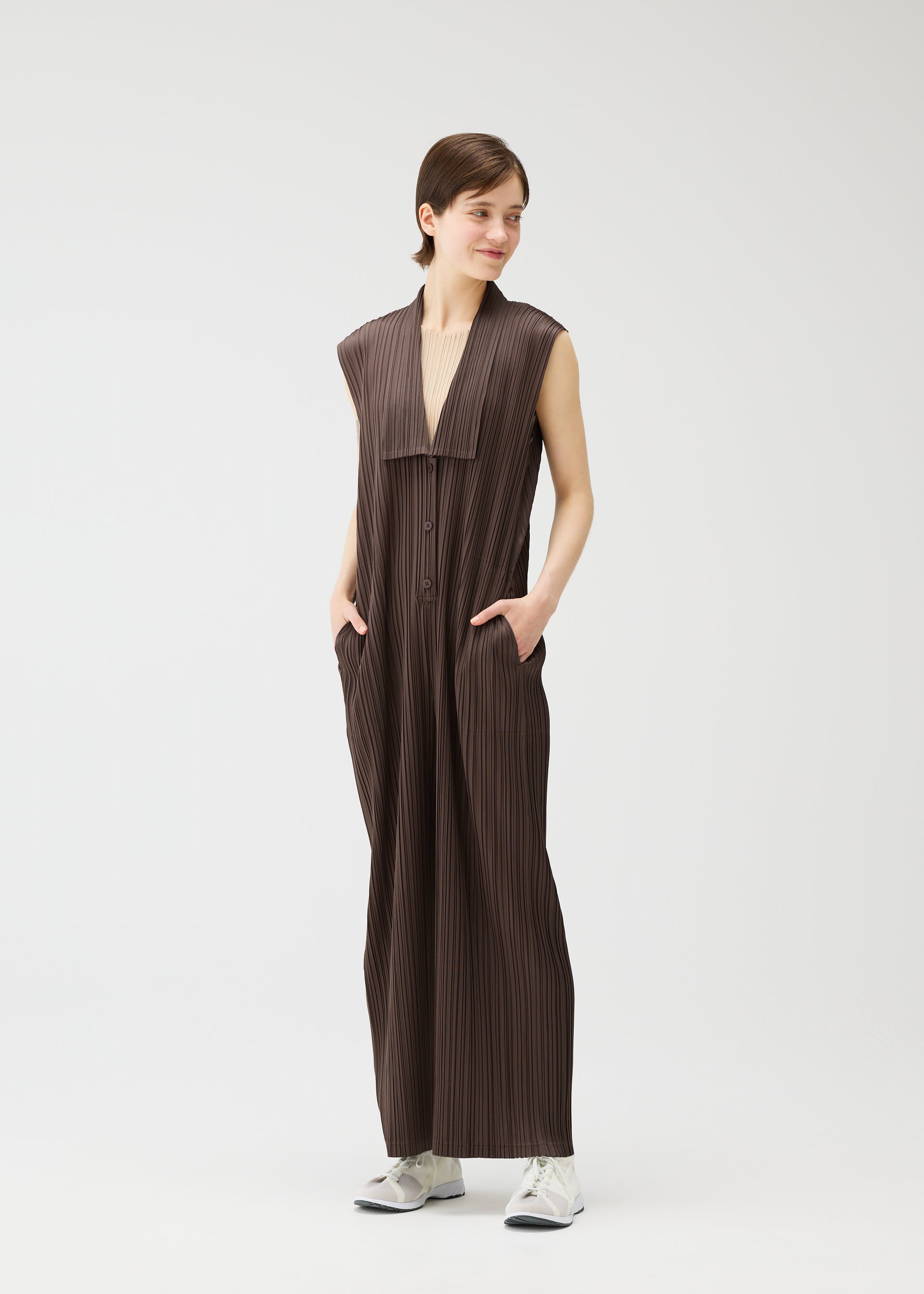 A model wears the Pleats Please Issey Miyake LOOP BOTTOMS jumpsuit.