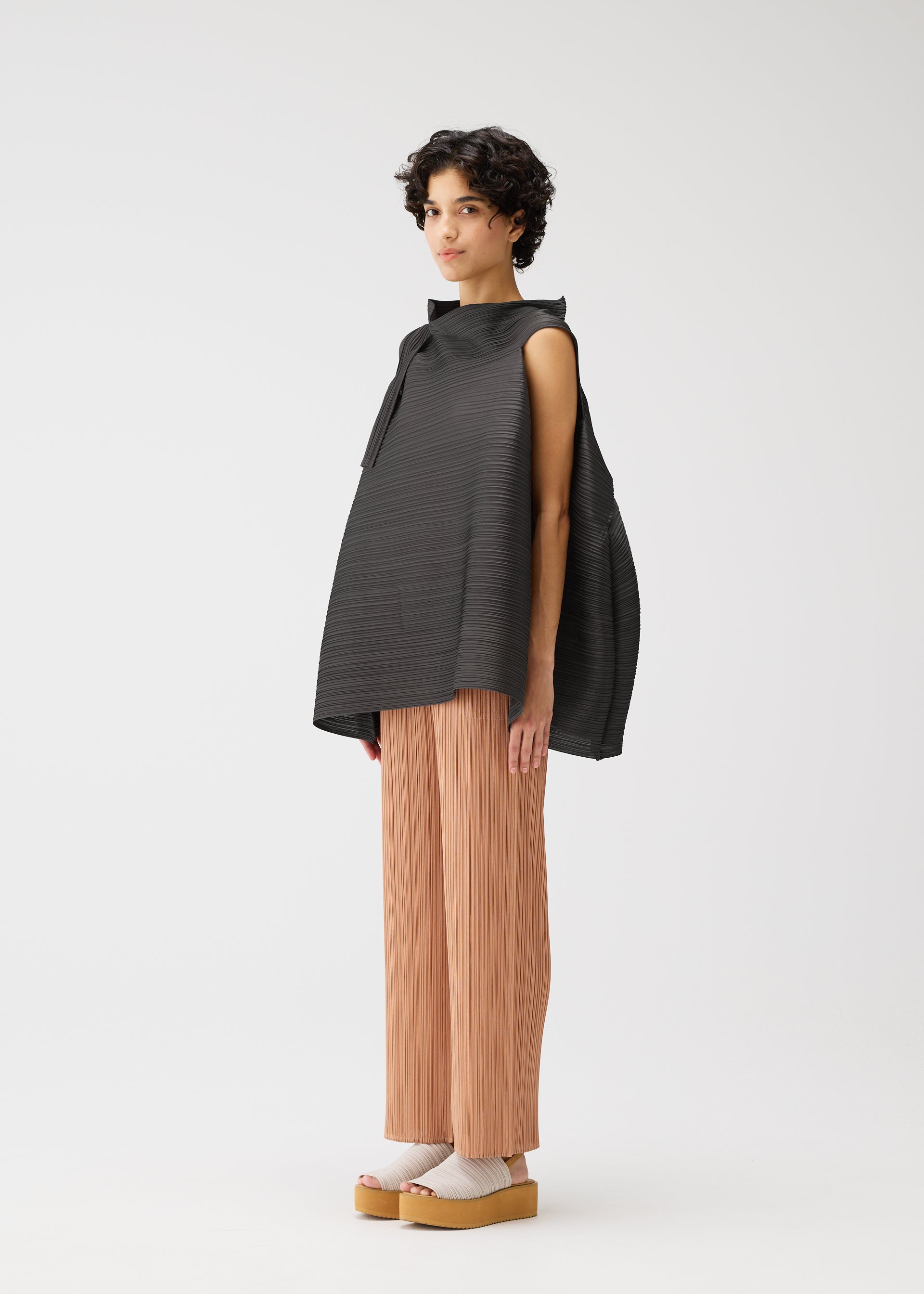 A model wears the PLEATS PLEASE ISSEY MIYAKE BOUNCY BASKET bouncy-basket-shirt-charcoal.