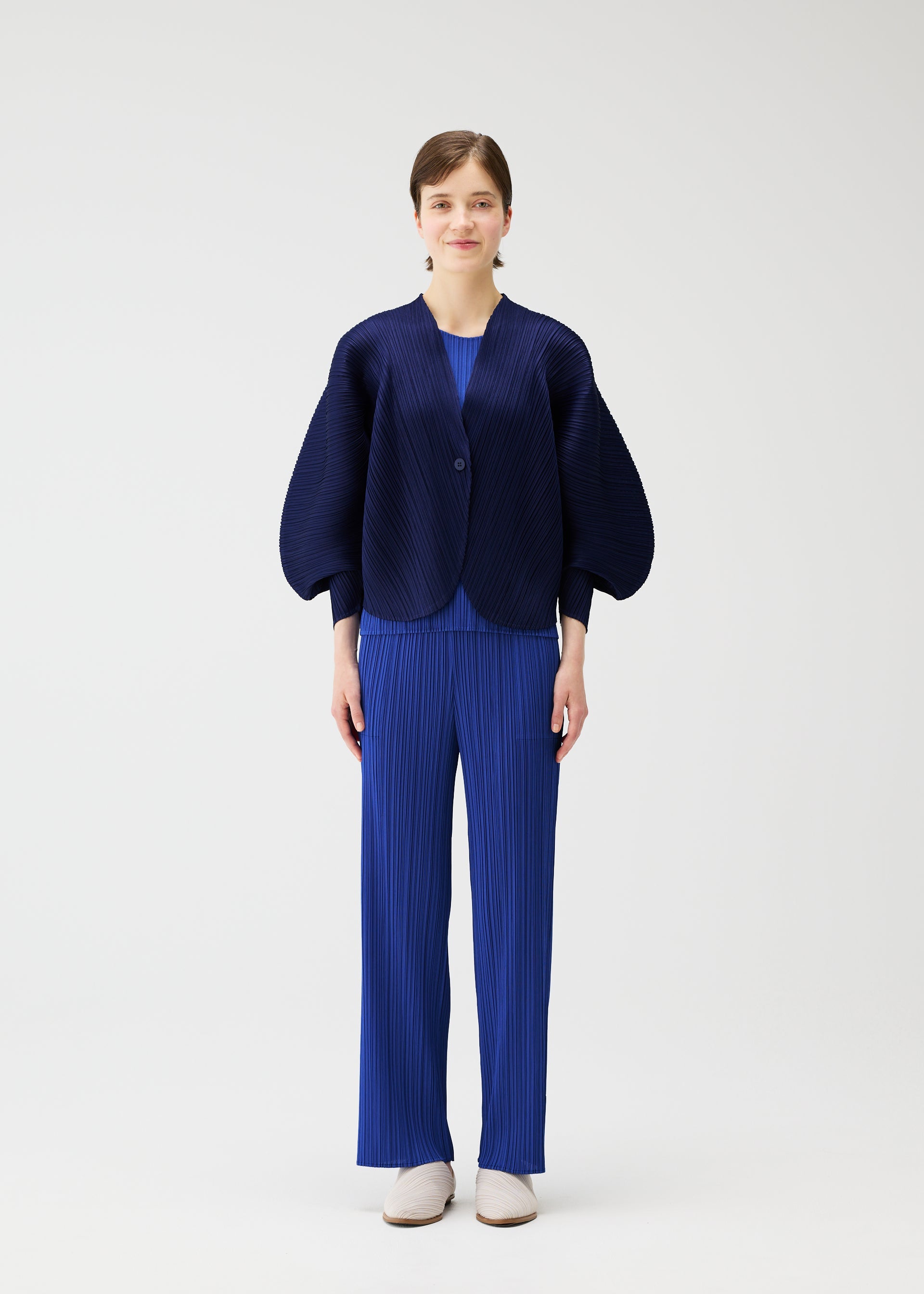 A model wears the PLEATS PLEASE ISSEY MIYAKE COAST pp66jo46243os.