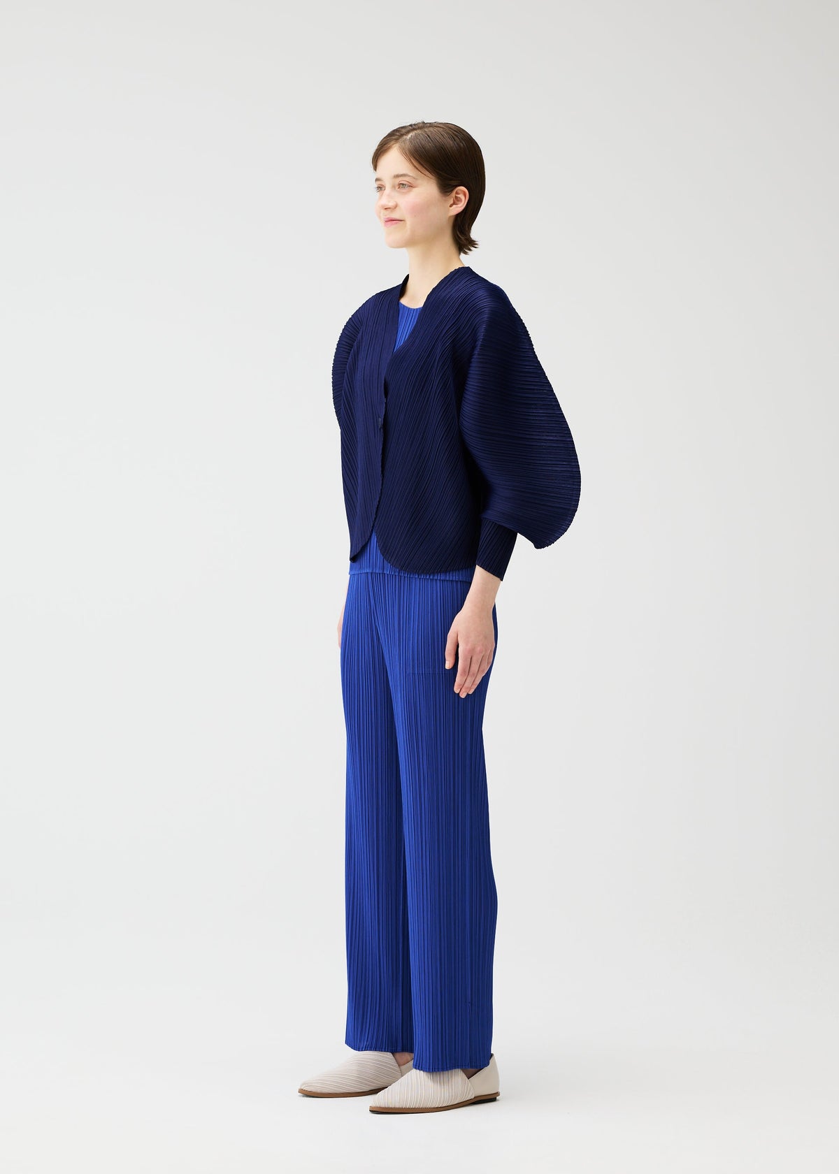 A model wears the PLEATS PLEASE ISSEY MIYAKE COAST pp66jo46275os.