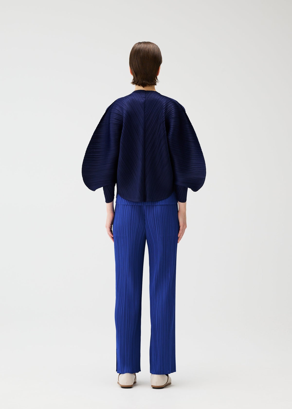 A model wears the PLEATS PLEASE ISSEY MIYAKE COAST pp66jo46243os.