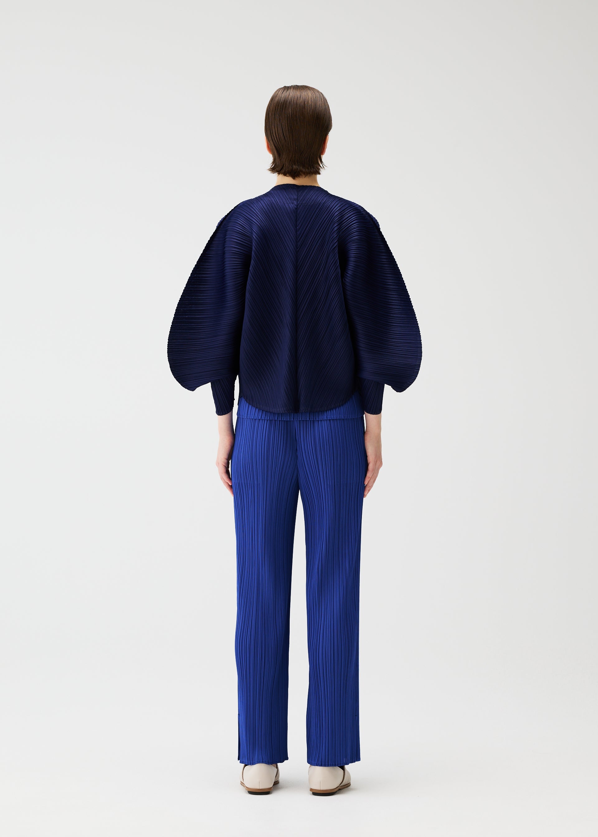 A model wears the PLEATS PLEASE ISSEY MIYAKE COAST pp66jo46243os.