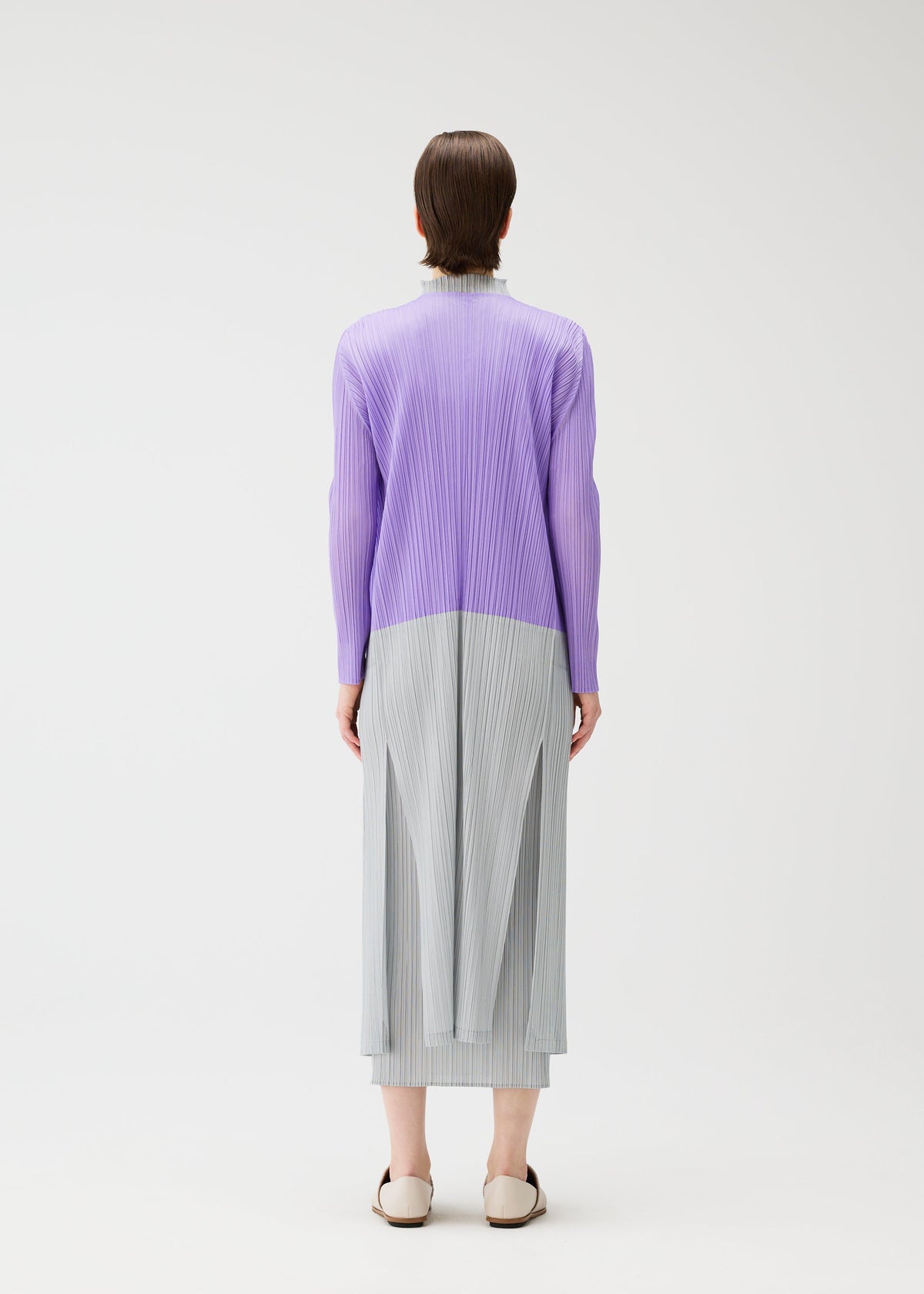 A model wears the Pleats Please Issey Miyake SWING cardigan.