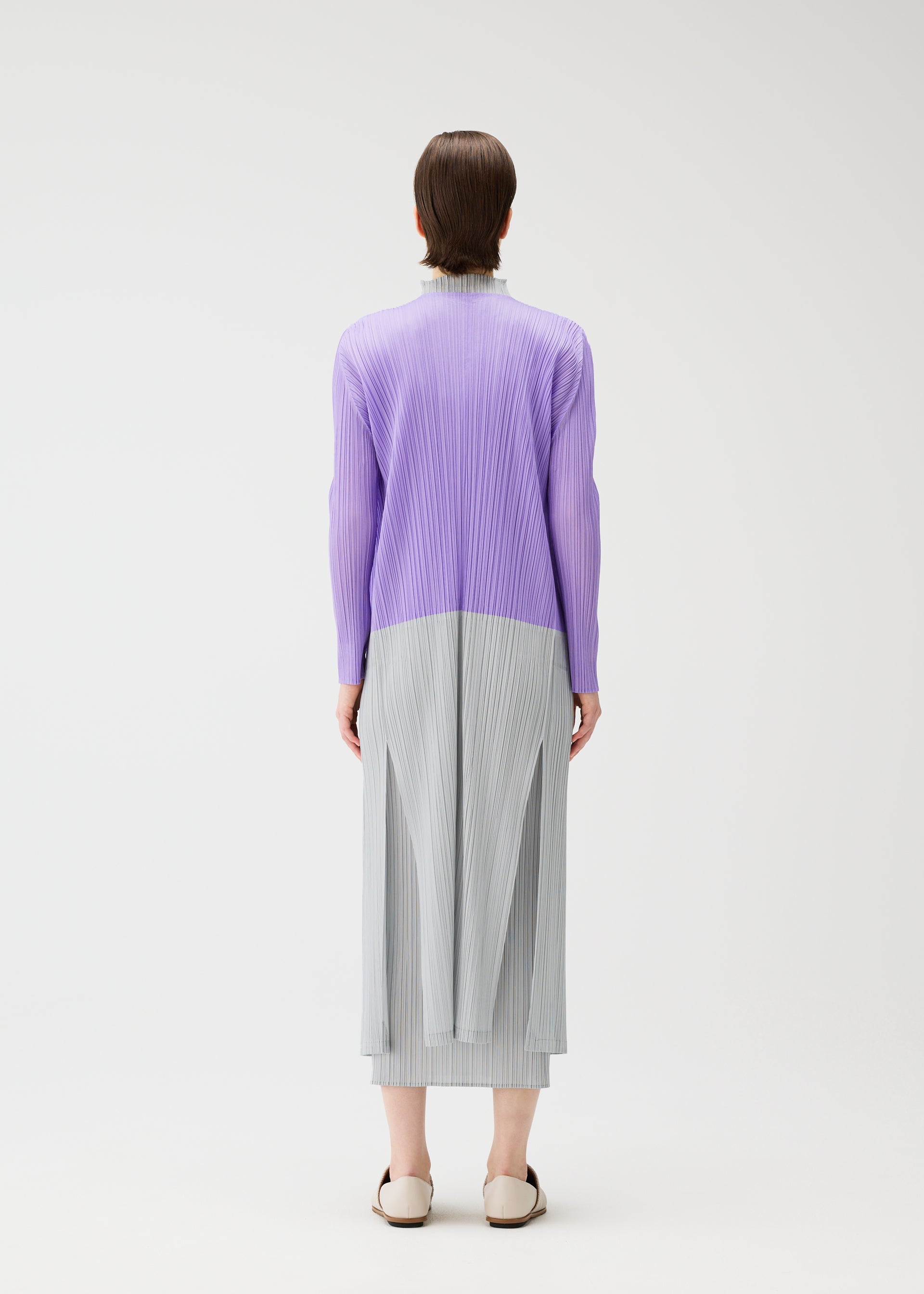 A model wears the Pleats Please Issey Miyake SWING cardigan.