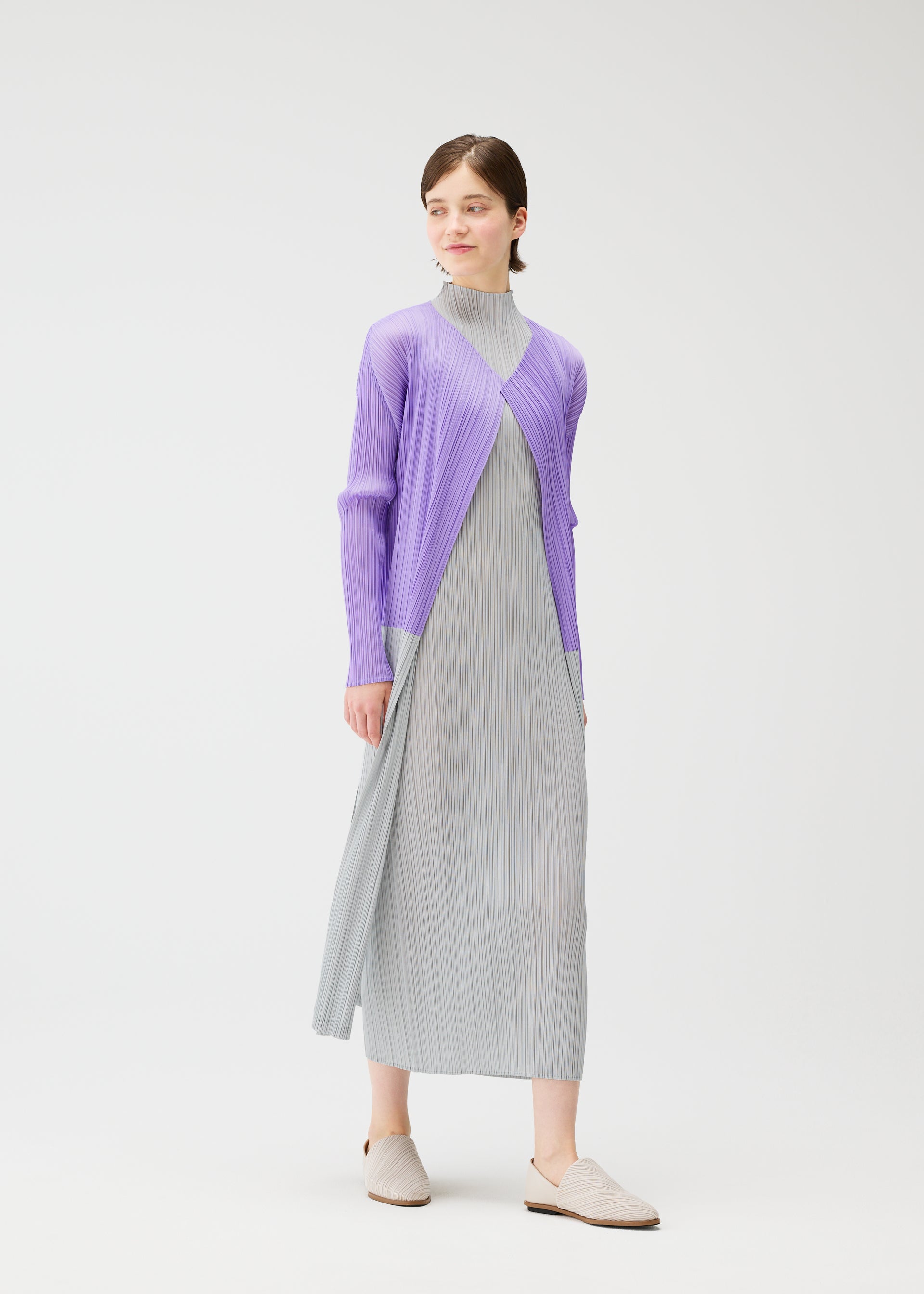 A model wears the Pleats Please Issey Miyake SWING cardigan.